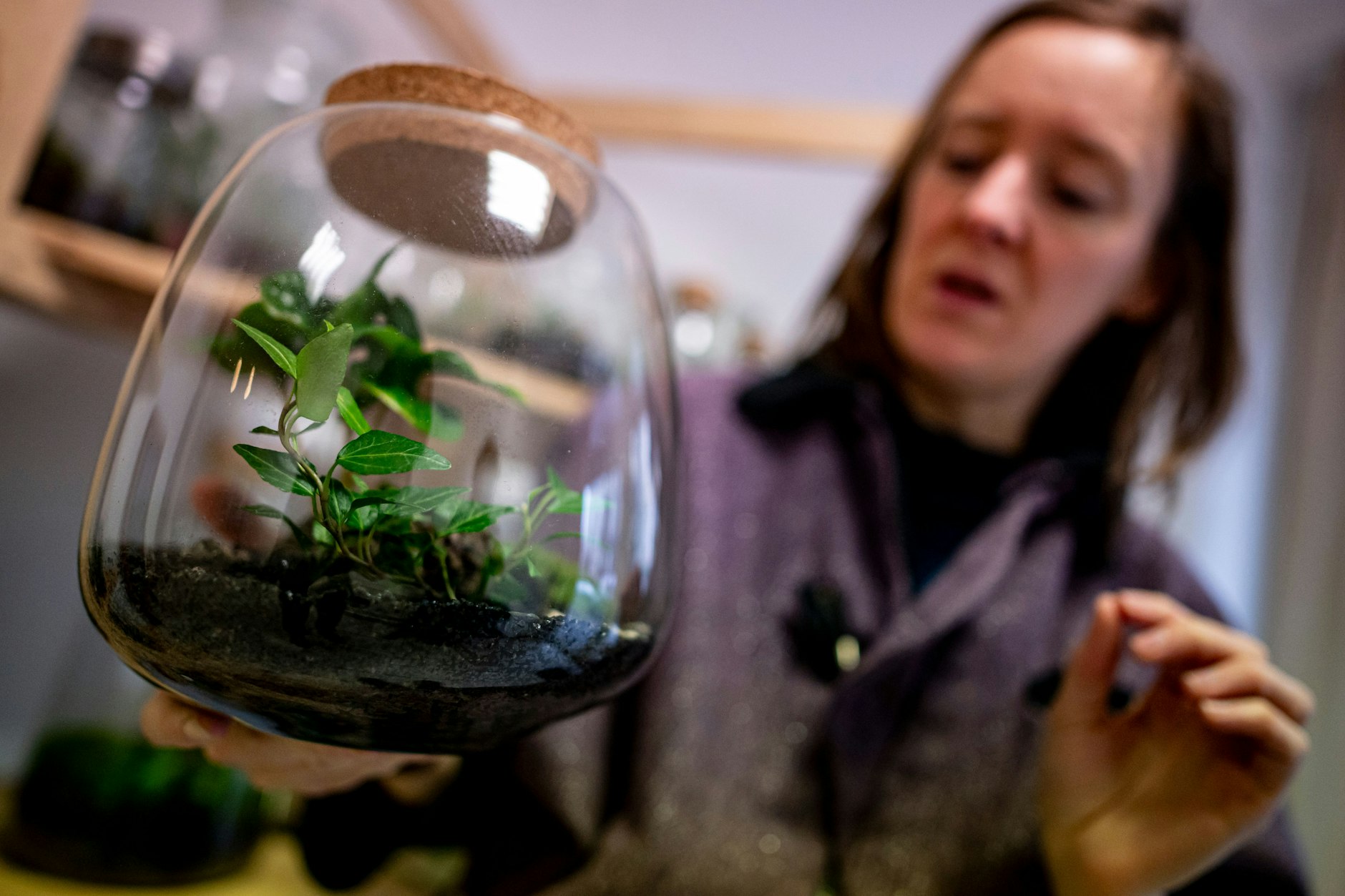 Aurelie Morgen, Inhaberin von Petite Jungle, hält einen Flaschengarten in ihrer Werkstatt in der Hand. Besonders für kleine Stadtwohnungen sind sie als Alternative zu großen Zimmerpflanzen beliebt.