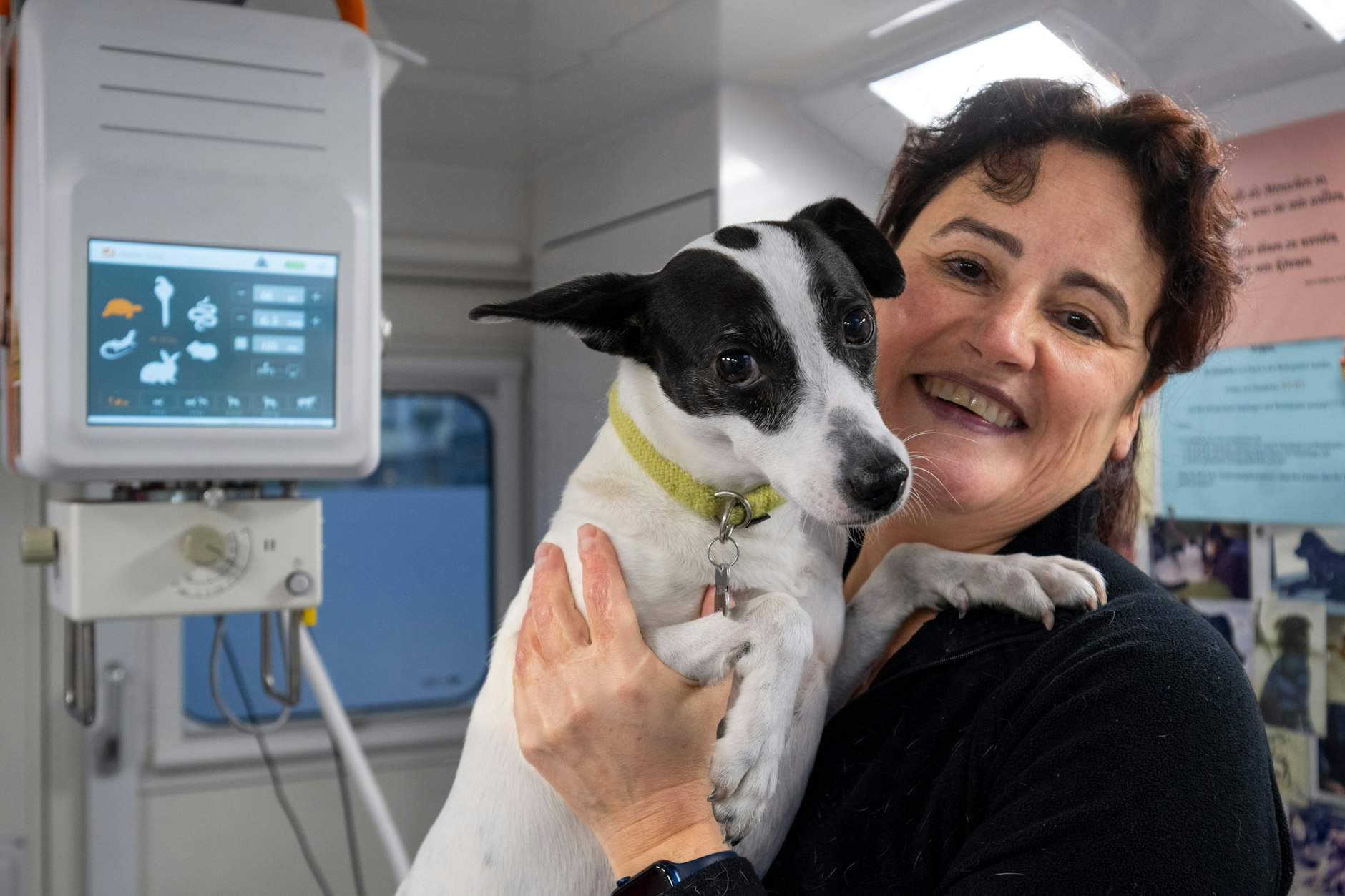 Tierärztin Jeanette Klemmt steht während einer Sprechstunde in ihrer mobilen Tierarztpraxis und hält ihren Hund Amanda auf dem Arm. Sie engagiert sich für das Projekt HundeDoc, das aus Spenden finanziert wird. 