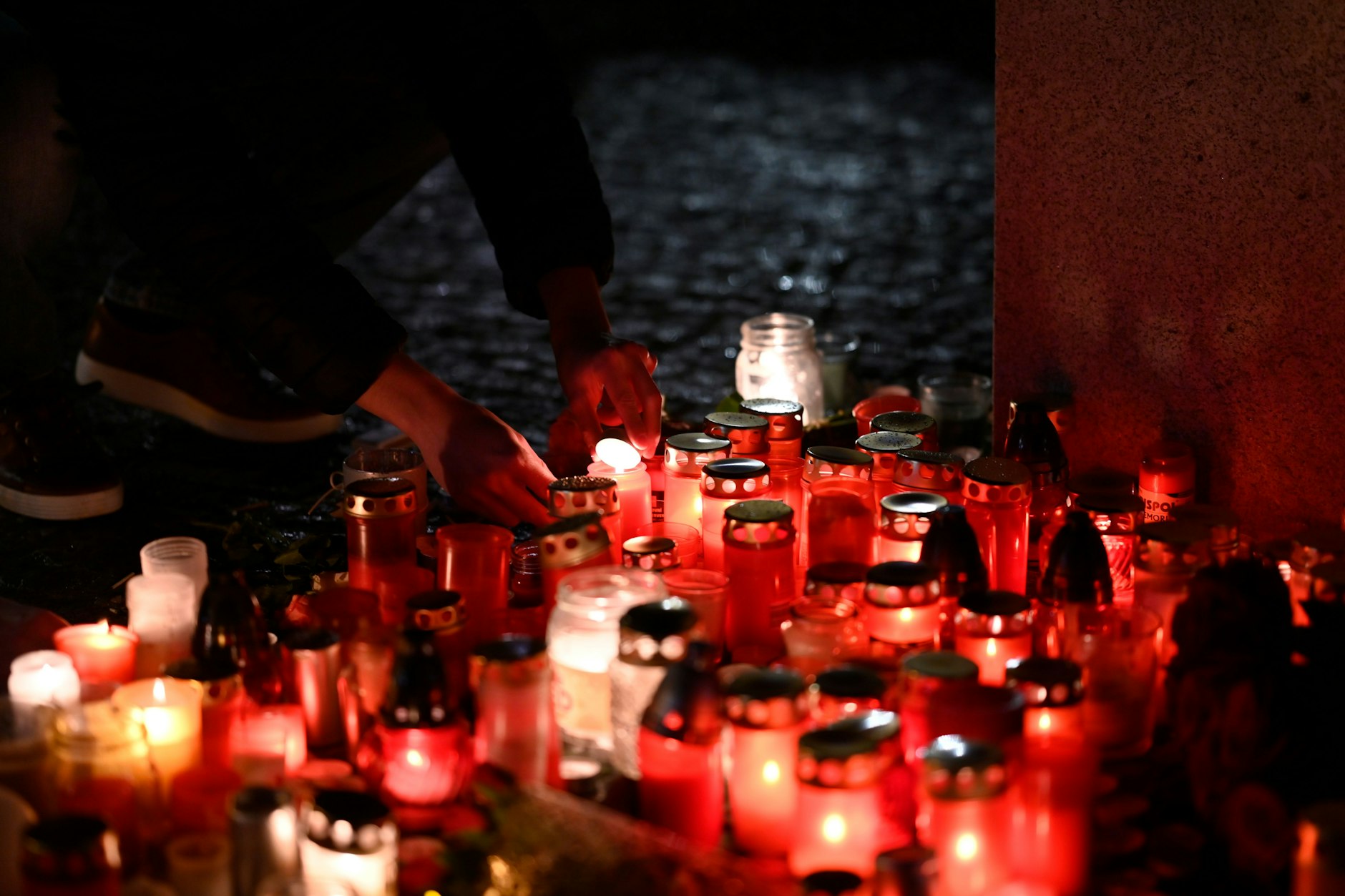 Una persona enciende una vela frente al edificio de la Facultad de Artes de la Universidad Carolina en el centro de Praga.