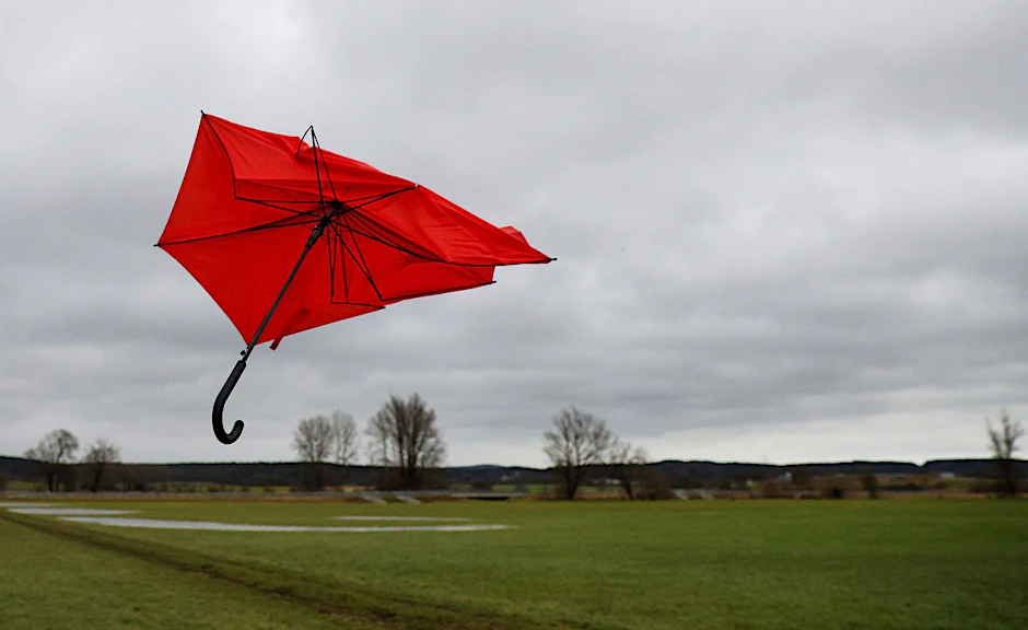 Ein kaputter Regenschirm fliegt im Wind.  