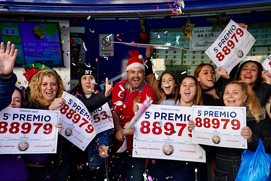 Gewinner der Weihnachtslotteriepreise feiern vor einer Lottoannahmestelle in Málaga.  