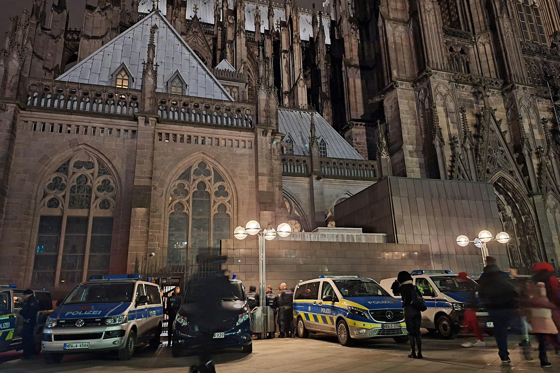 Am Samstagabend sollte der Kölner Dom wegen eines Gefahrenhinweises von Spürhunden durchsucht werden. Einsatzfahrzeuge der Polizei stehen deshalb vor der Kathedrale.