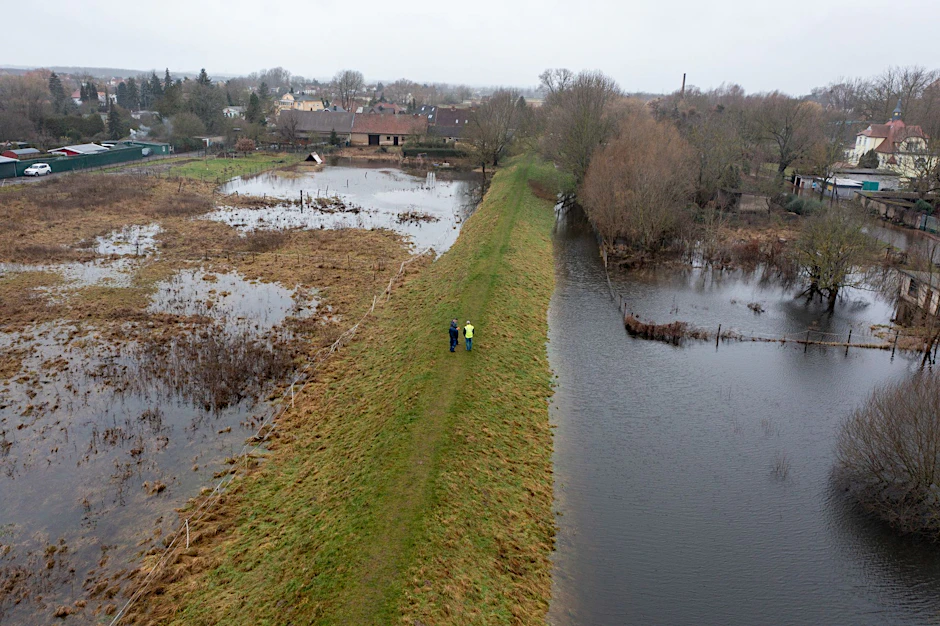 Mitarbeiter des Landesbetriebs für Hochwasserschutz in Wolmerstedt in Sachsen-Anhalt laufen einen Deich ab.  
