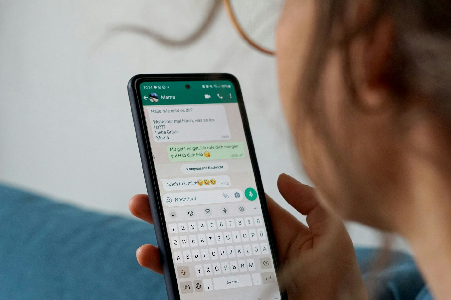 Eine Frau hält ein Smartphone in der Hand, auf dem der Messengerdienst WhatsApp geöffnet ist.&nbsp;