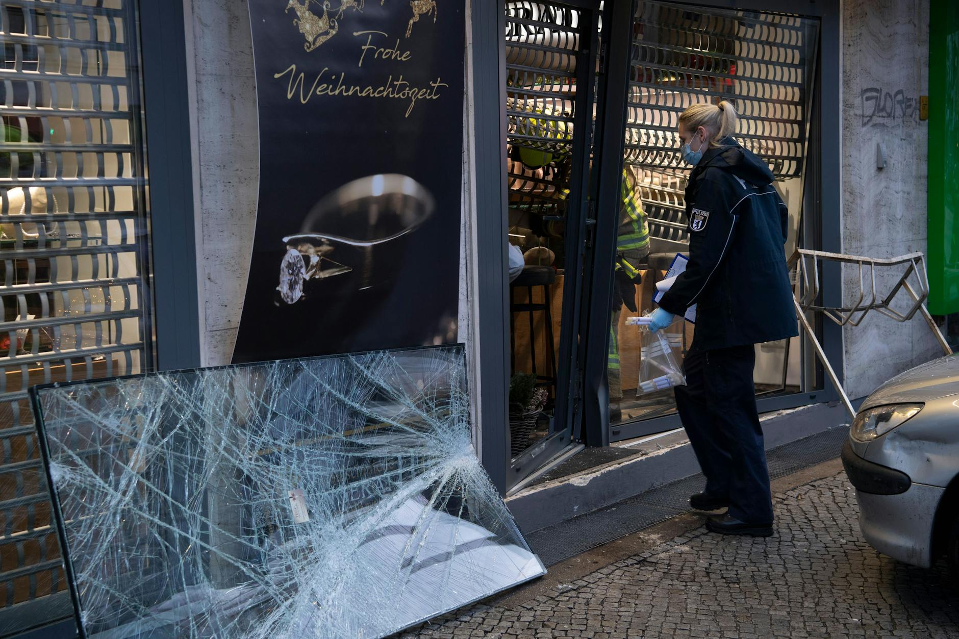 Einsatzkräfte der Polizei gehen in ein beschädigtes Juweliergeschäft an der Berliner Straße in Tegel. Mit einem Kleinwagen sind am Morgen bislang unbekannte Täter in das Geschäft gefahren. Dabei wurde der Eingangsbereich zerstört. Die Kriminalpolizei hat die Ermittlungen übernommen.