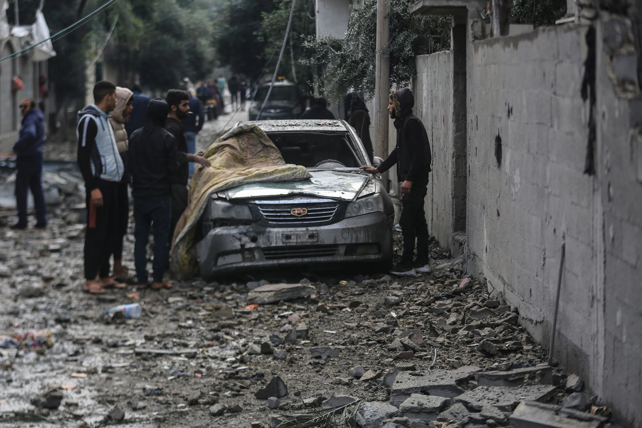 Palästinenser inspizieren ein beschädigtes Auto nach einem schweren israelischen Bombardement des Flüchtlingsviertels Al-Maghasi im zentralen Gazastreifen.  