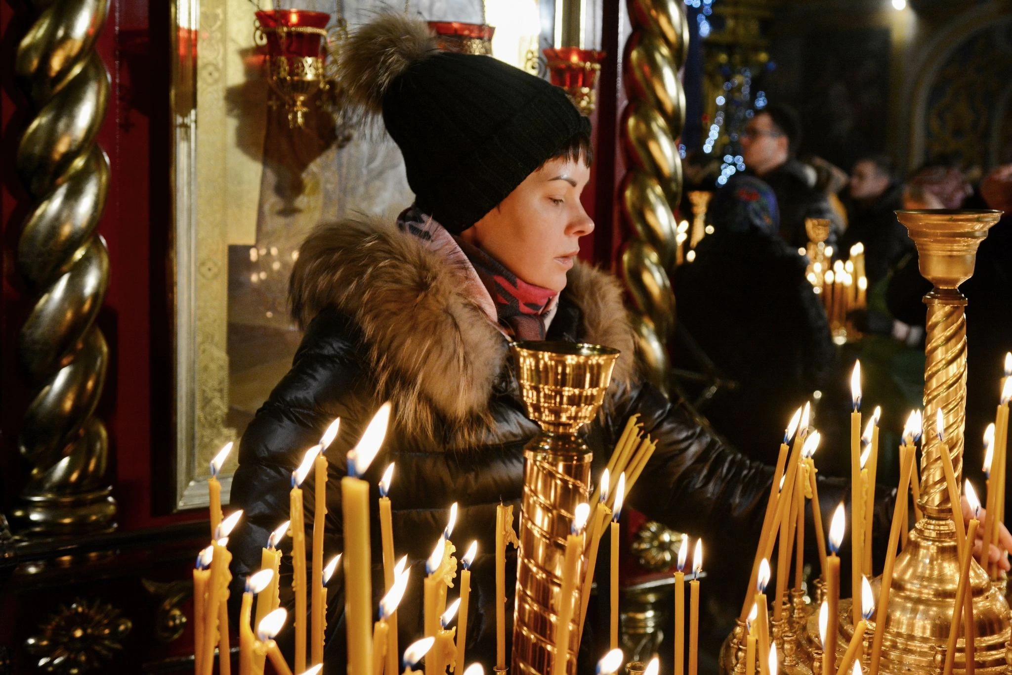 Eine Frau zündet während eines orthodoxen Weihnachtsgottesdienstes in Kiew eine Kerze an.   ZUMA Press Wire/dpa