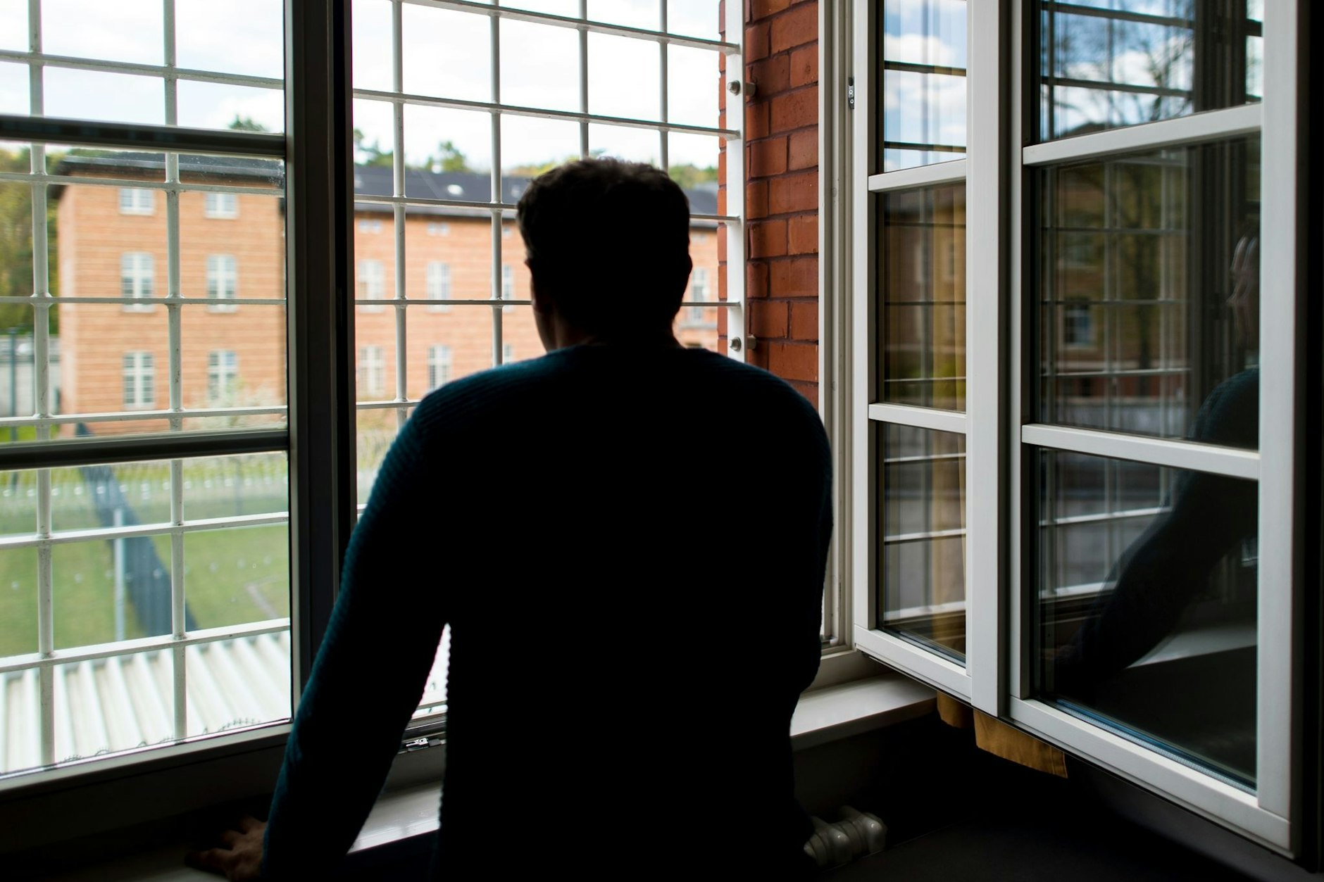 Ein Straftäter steht vor einem vergitterten Fenster des Maßregelvollzuges in Berlin-Reinickendorf.
