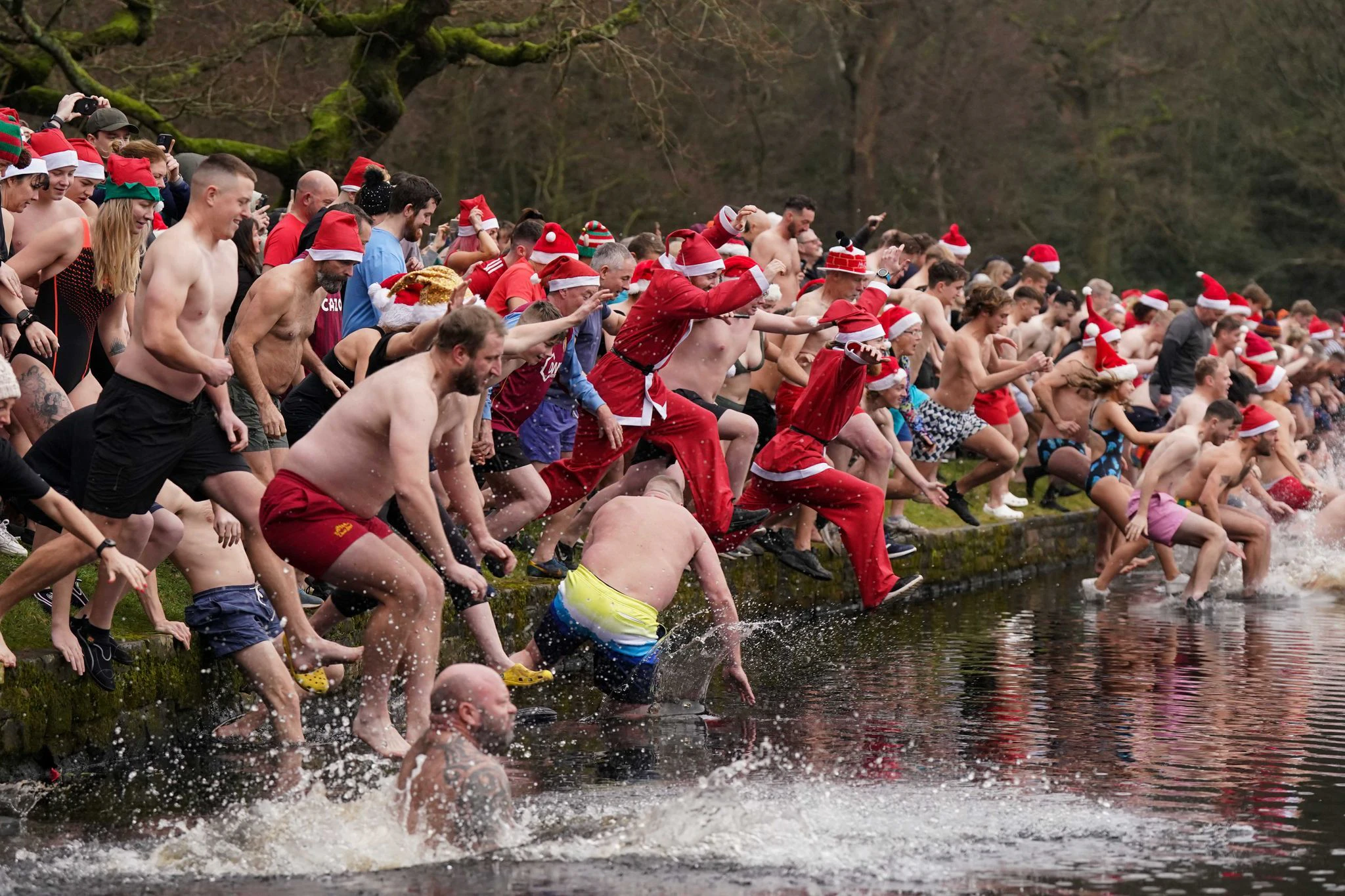 Ab ins kalte Nass: Menschen springen in Sutton Coldfield in Großbritannien in den Blackroot Pool zum Weihnachtsschwimmen, eine jährliche Tradition.  