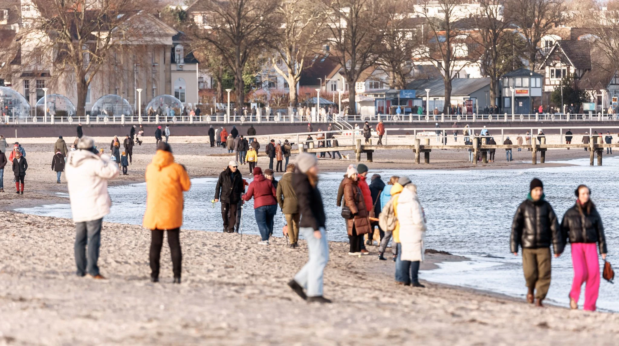 Nach dem leckeren Essen geht es raus in die Natur: Ausflügler am ersten Weihnachtsfeiertag am Strand in Travemünde in Schleswig-Holstein.  