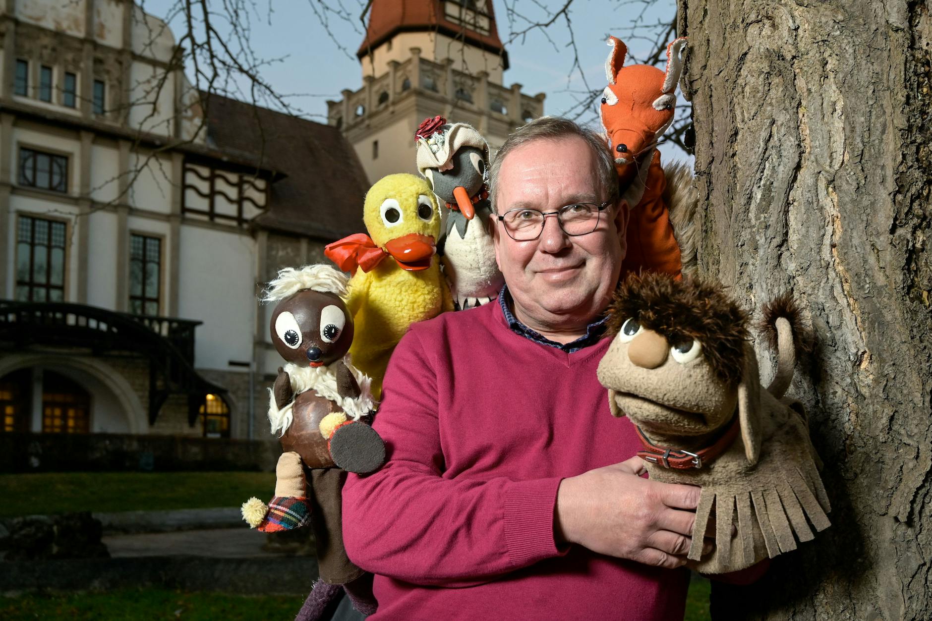 Tourleiter Mario Behnke mit den Originalpuppen Moppi, Pittiplatsch, Schnatterinchen, Herr Fuchs und Frau Elster vor dem Kurhaus in Bernburg.