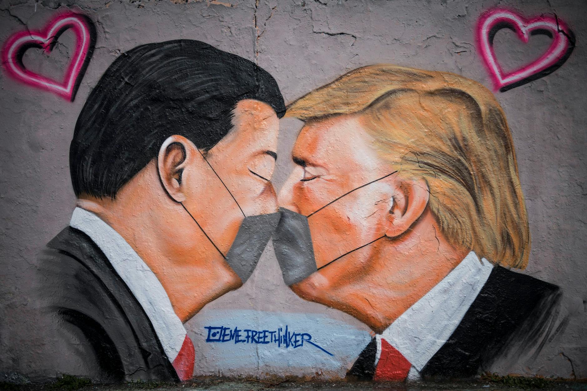 Der damalige US-Präsident Donald Trump und Xi Jinping, Präsident der Volksrepublik China, sind auf einem Graffito des Straßenkünstlers Eme Freethinker von 2020 küssend und mit Mundschutz zu sehen.
