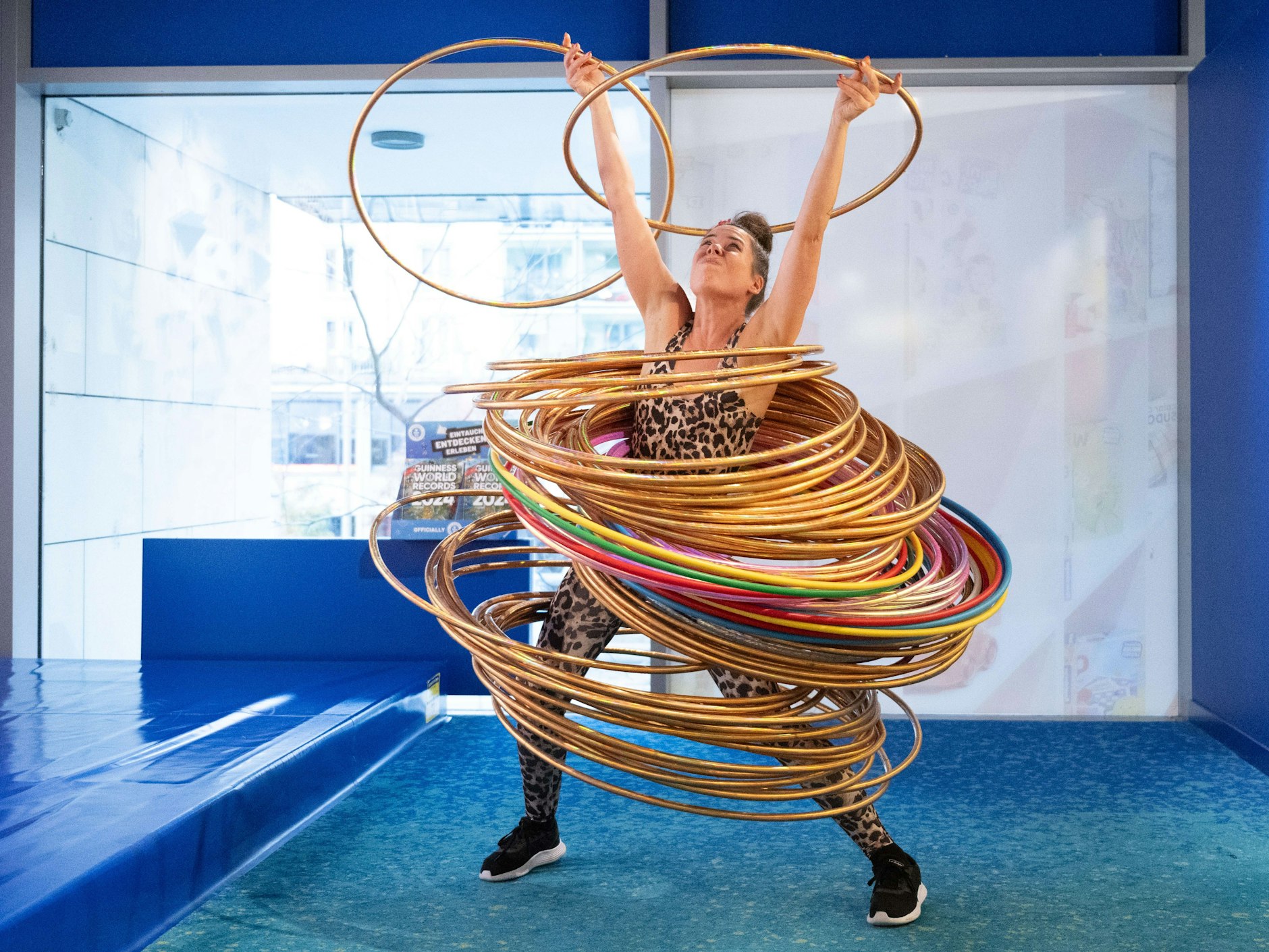 Dunja Kuhn bewegt bei einem Weltrekordversuch 84 Hula-Hoop-Reifen mit ihrem Körper. Damit übertrifft Kuhn ihren bisherigen Rekord aus dem Jahr 2021 um 14 weitere Reifen.