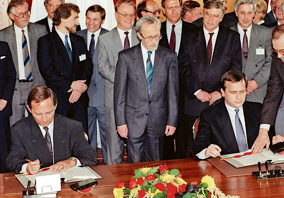 Bundesinnenminister Wolfgang Schäuble (l.) und DDR-Staatssekretär Günther Krause bei der Unterzeichnung der Urkunden zum Einigungsvertrag am 31.08.1990. In der Mitte DDR-Ministerpräsident Lothar de Maizière. Im Palais Unter den Linden in Berlin wurde der Beitritt der DDR zur Bundesrepublik per 3. Oktober 1990 besiegelt.