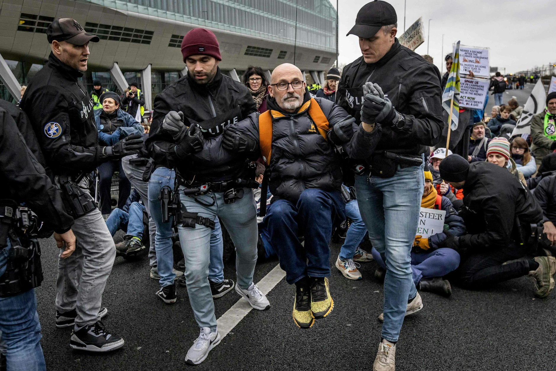 Autobahnblockade: Ein Protestler wird von Polizisten weggetragen.