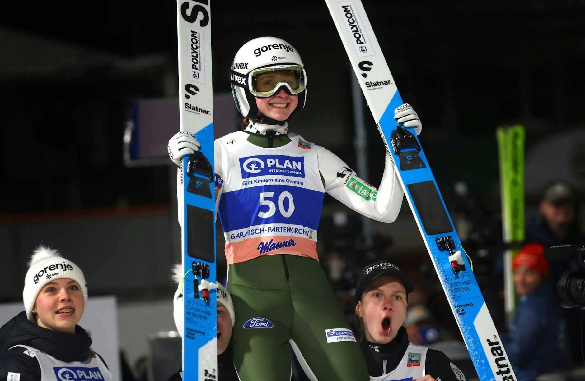 Jubelstimmung beim slowenische Team - Nica Prevc wird nach ihrem Sieg an der Großen Olympiaschanze in Garmisch-Partenkirchen von ihren Teamkolleginnen auf den Schultern getragen.  