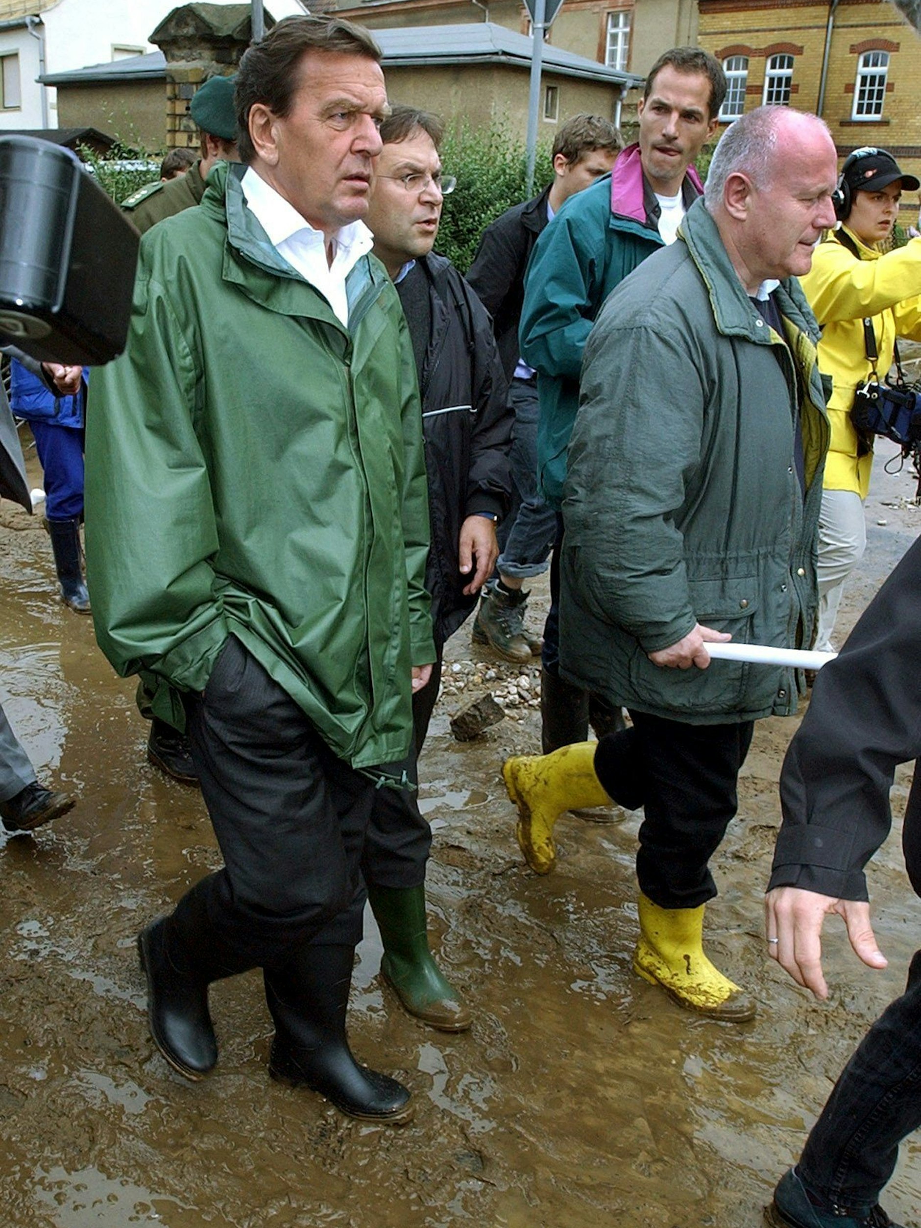 Der damalige Bundeskanzler Gerhard Schröder (SPD, l) und der damalige sächsische Ministerpräsident Georg Milbradt (CDU) gehen durch die nach dem Hochwasser der&nbsp;Elbe verwüstete sächsische Kreisstadt Grimma.&nbsp;