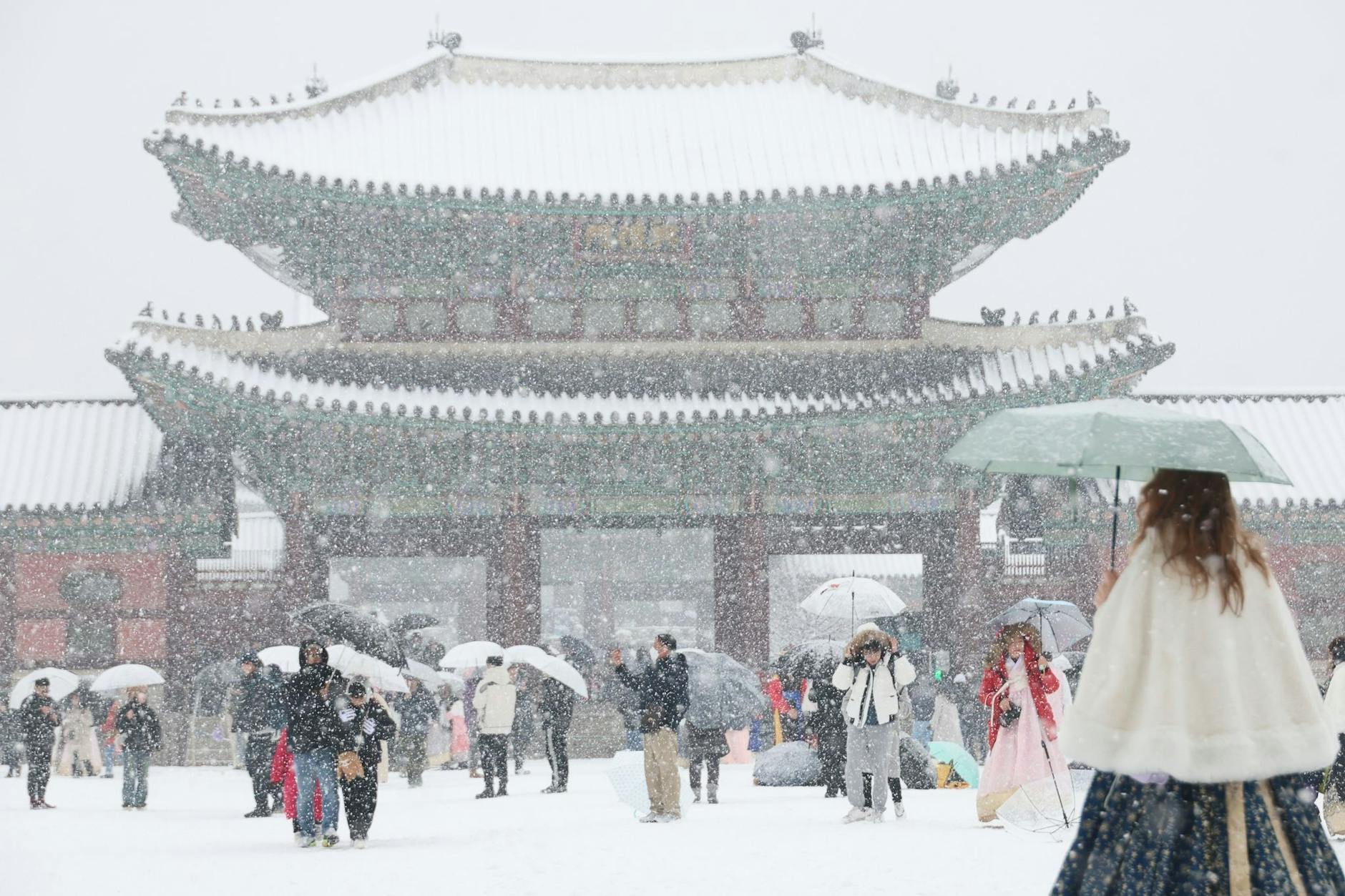 Ein besonderes Foto-Motiv: Touristen besuchen den Gyeongbok-Palast im Zentrum Seouls bei starkem Schneefall.