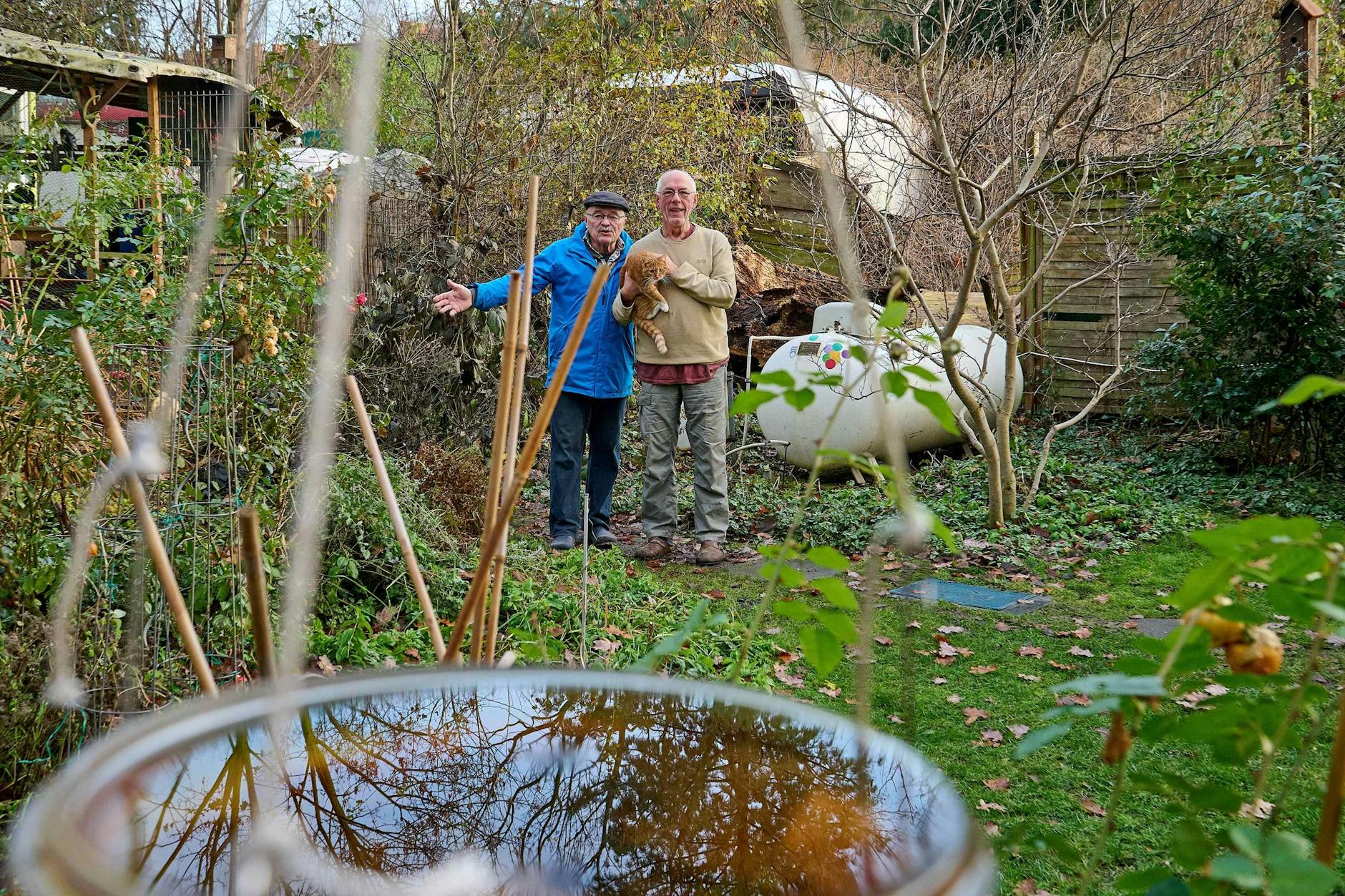 Wolfgang Niedrich (l.) und Karsten Zander im Garten vor dem Wagen von Karsten Zander auf dem Rollheimer-Wagenplatz in Neukölln.