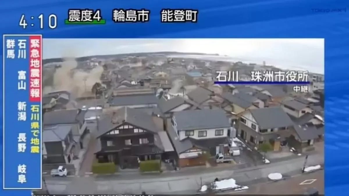 Eine Kamera filmt während des Bebens, wie im Hintergrund ein Haus zerstört wird.