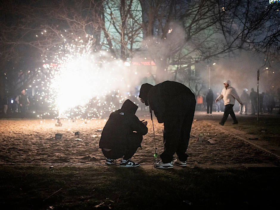Jugendliche zünden eine Rakete in Berlin an.