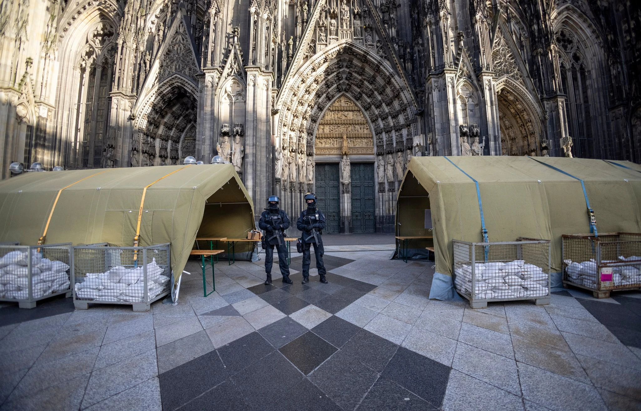 dpatopbilder - Polizisten mit Maschinenpistolen stehen vor dem Kölner Dom. Nach dem Terroralarm für das Gotteshaus sind drei weitere Verdächtige festgesetzt worden.  