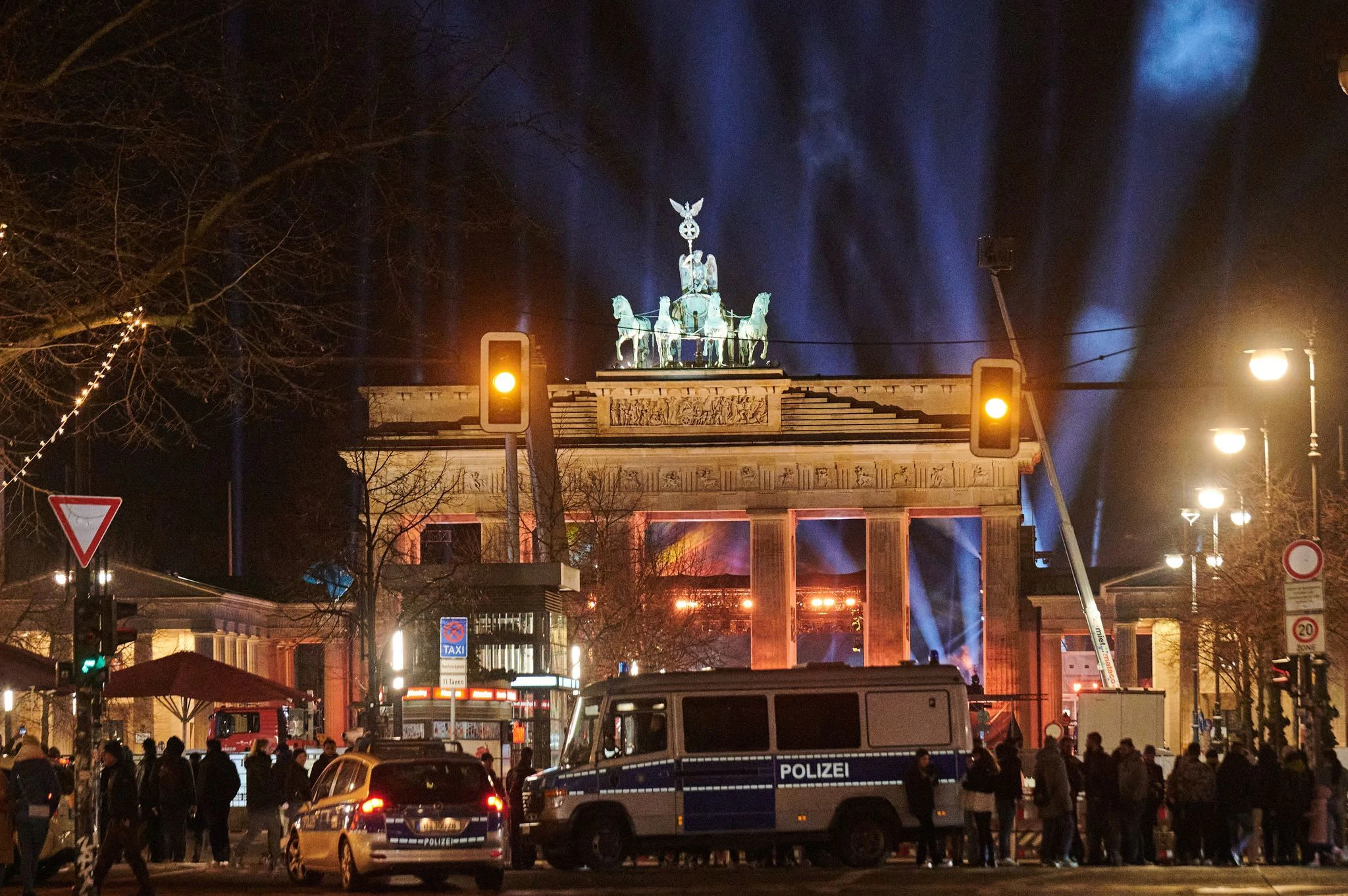 Silvester in Berlin: Polizeiwagen stehen vorm angestrahlten Brandenburger Tor.  