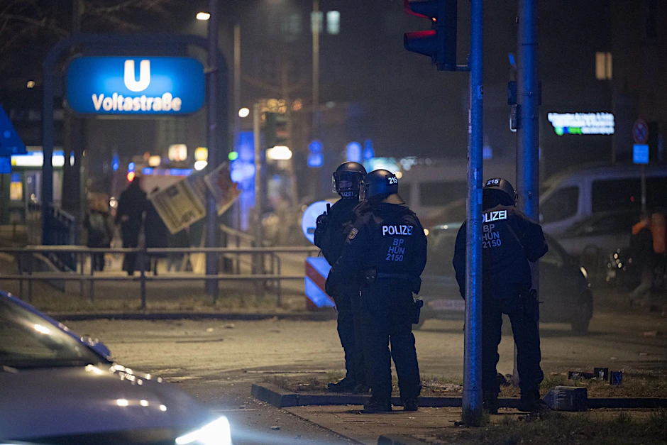 Polizeibeamte stehen in der Silvesternacht im Stadtteil Gesundbrunnen an der Voltastraße.  