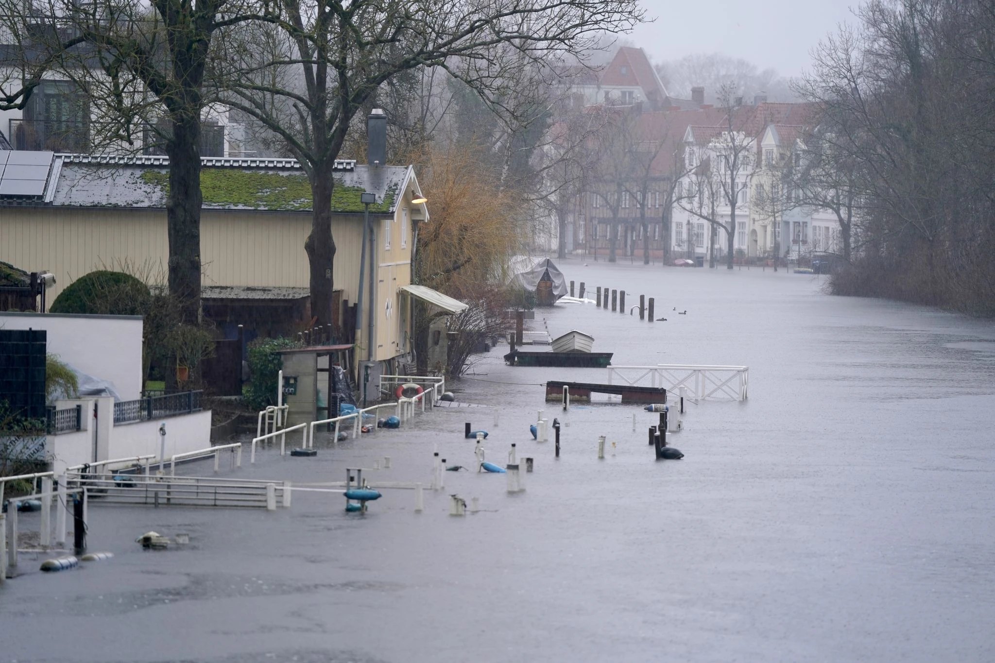 Gehwege und Bootsstege sind am Ufer der Trave in Lübeck vom Hochwasser umgeben.  