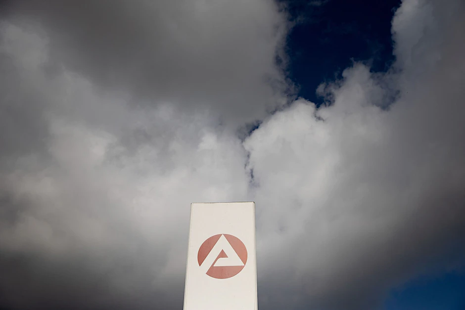PRODUKTION - Wolken ziehen über ein Schild der Agentur für Arbeit.  