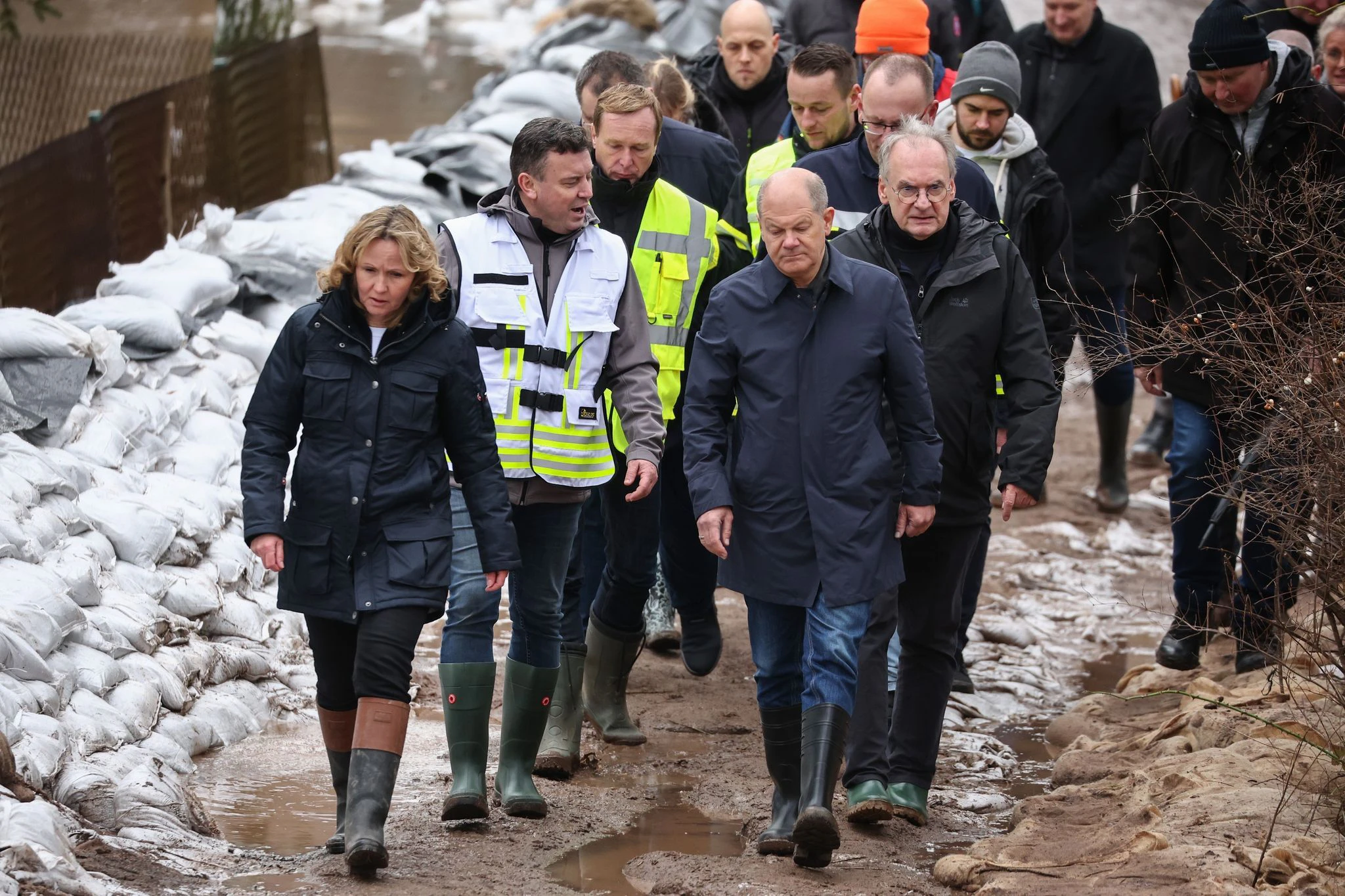 Bundeskanzler Olaf Scholz (vorne rechts) trägt bei seinem Besuch im Hochwassergebiet in Sangerhausen Gummistiefel.  