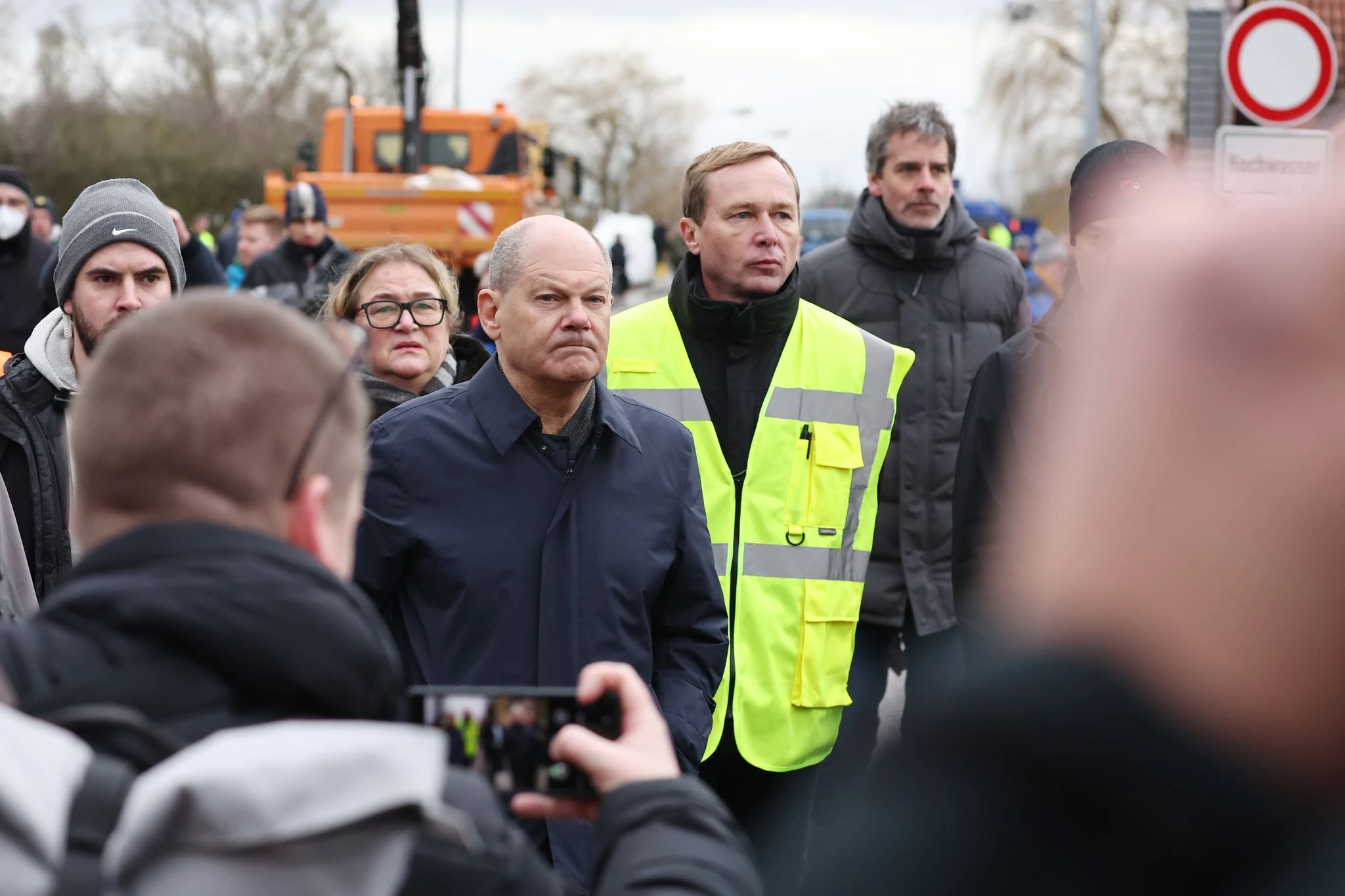 Kanzler Olaf Scholz zusammen mit dem Leiter des Katastrophenschutz Mansfeld-Südharz, Sven Vogler, im Gespräch mit Anwohnern in Sangerhausen.  