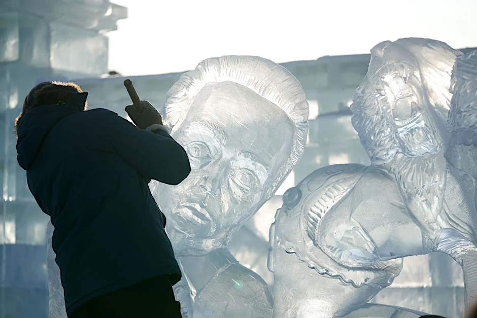 Ein Teilnehmer des Wettbewerbs arbeitet an einer Eisskulptur in der Harbin Ice-Snow World.  