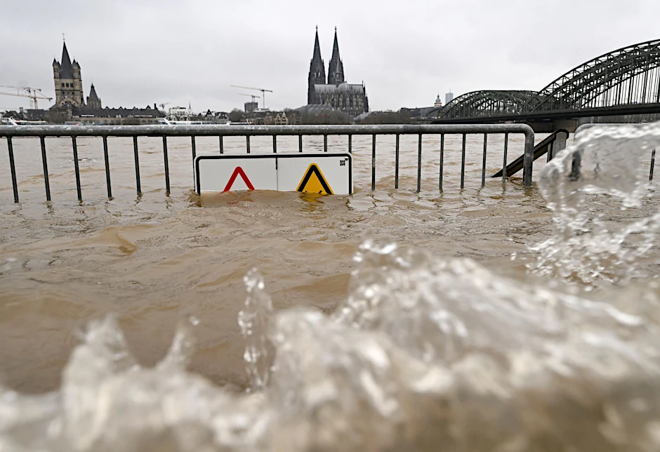 Blick auf den Hochwasser führenden Rhein vor dem Dom und der Hohenzollernbrücke.  