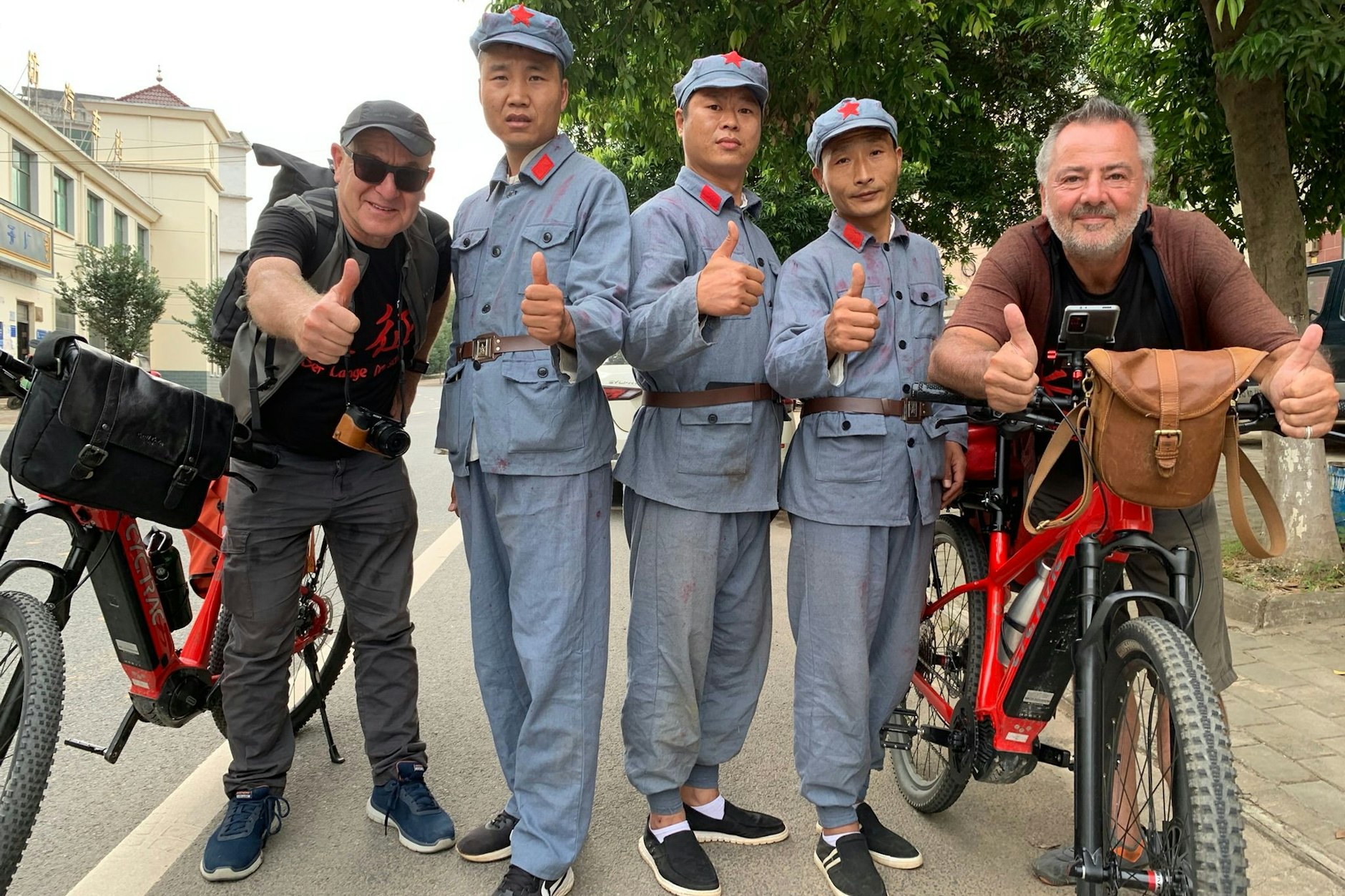 Christian Y. Schmidt (l.) und Volker Häring (r.) auf einer Landstraße in der Provinz Guangxi mit einer Schauspielertruppe. Sie fährt in den historischen Uniformen der damaligen Roten Armee im Auto die Route des Langen Marsches nach, um Schlüsselszenen nachzuspielen. Die Clips werden im Internet gestreamt. Ihr Vlog hat angeblich 30 Millionen Follower.