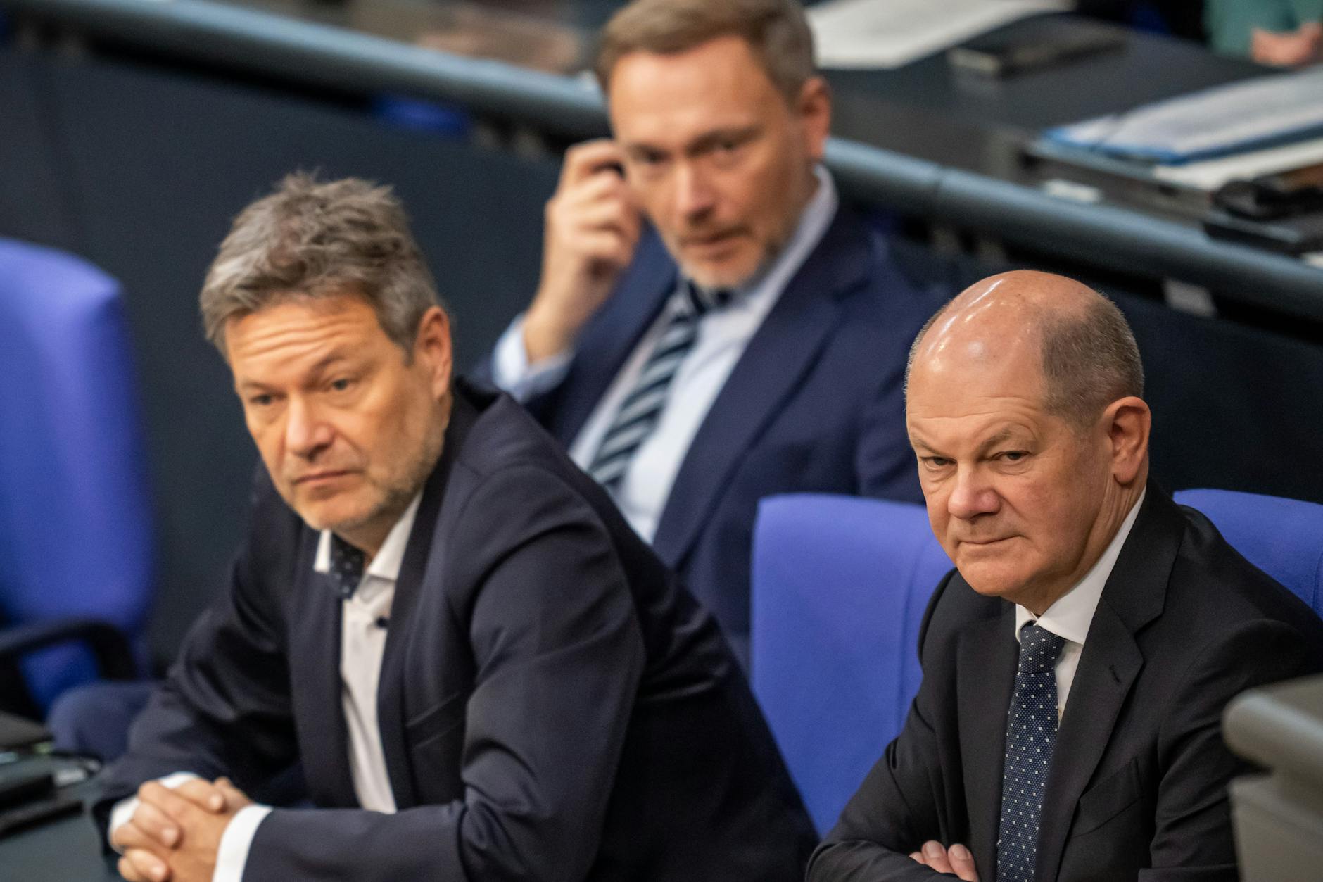 Bundeskanzler Olaf Scholz (r.) verfolgt neben Wirtschaftsminister Robert Habeck (l.) und Finanzminister Christian Lindner die Bundestagsdebatte zur Haushaltslage.