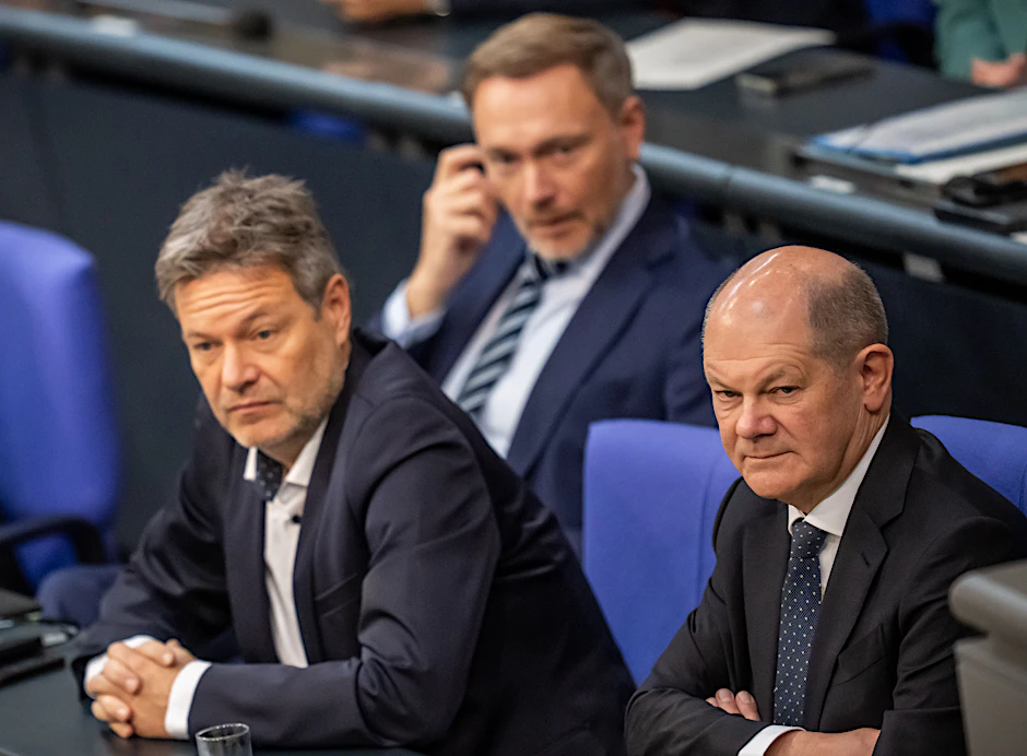 Bundeskanzler Olaf Scholz (r.) verfolgt neben Wirtschaftsminister Robert Habeck (l.) und Finanzminister Christian Lindner die Bundestagsdebatte zur Haushaltslage.