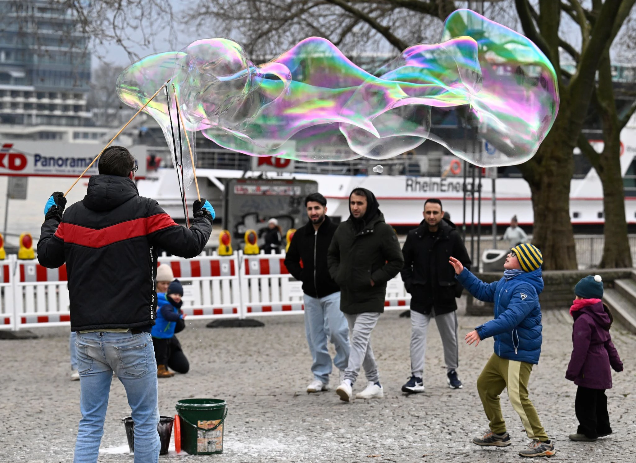 Schillernde Schönheit: Ein Seifenwasser-Künstler formt riesige bunte Seifenblasen in der Kölner Altstadt.  