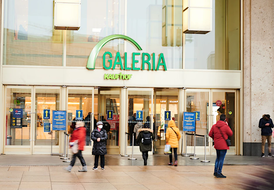 Menschen kommen aus oder gehen in den Galeria Kaufhof am Alexanderplatz.