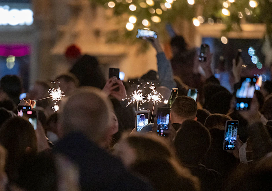 ARCHIV - Menschen machen Fotos mit ihren Smartphones, während sie den Jahreswechsel feiern.  