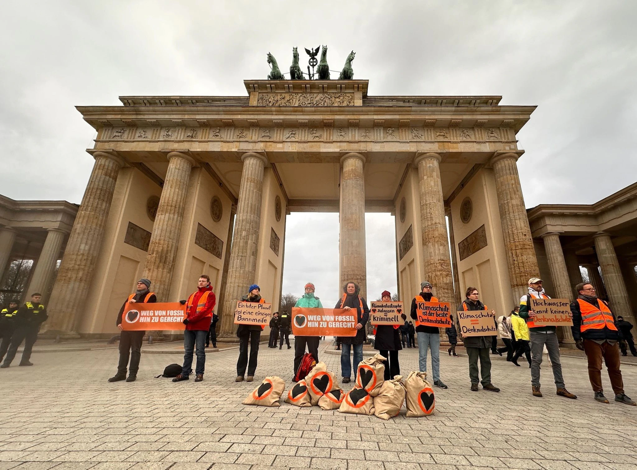 «Hochwasser kennt keinen Denkmalschutz»: Mit Sandsäcken und Bannern demonstrieren Aktivisten der Letzten Generation vor dem Brandenburger Tor in Berlin, um vor den andauernden Starkregenfällen in Deutschland zu warnen.  