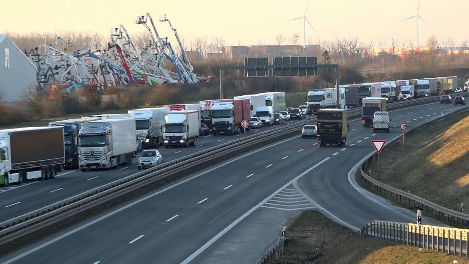 Lkw stauen sich auf der B101 unweit vom Güterverkehrszentrum (GVZ), das im Rahmen der Bauernproteste blockiert wurde. Im GVZ sind viele große Logistik-Unternehmen angesiedelt. Es kam zu einem langen Rückstau, wie eine Polizei-Sprecherin sagt. Das brandenburgische Verkehrsministerium befürchtet Verzögerungen für Warenlieferungen.