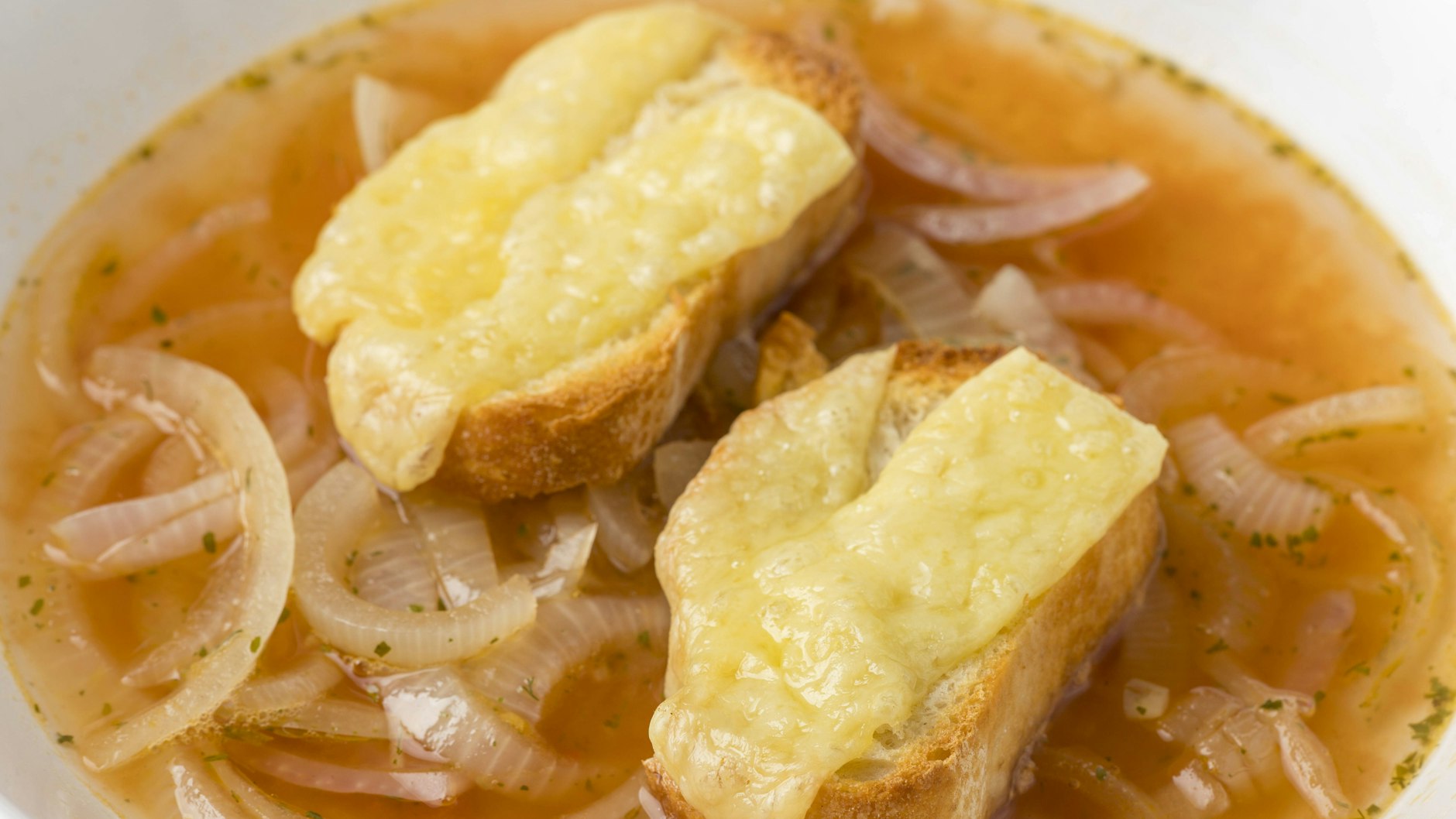Alte Brötchen verwerten: Die mit Käse überbackenen Brötchen-Scheiben passen perfekt zur Zwiebelsuppe.