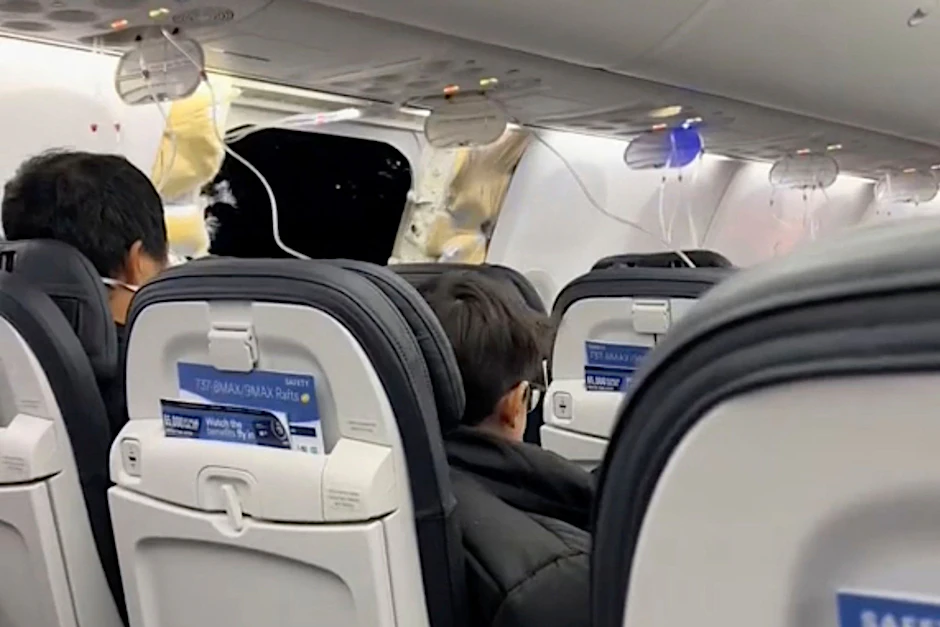 HANDOUT - Passagiere sitzen in der Boeing 737-9 Max in der Nähe des abgerissenen Kabinenteils.  