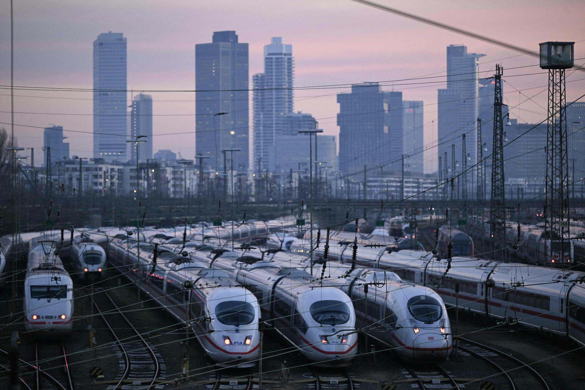 ICE-Hochgeschwindigkeitszüge stehen am 10. Januar 2024 vor der Skyline des Frankfurter Hauptbahnhofs still