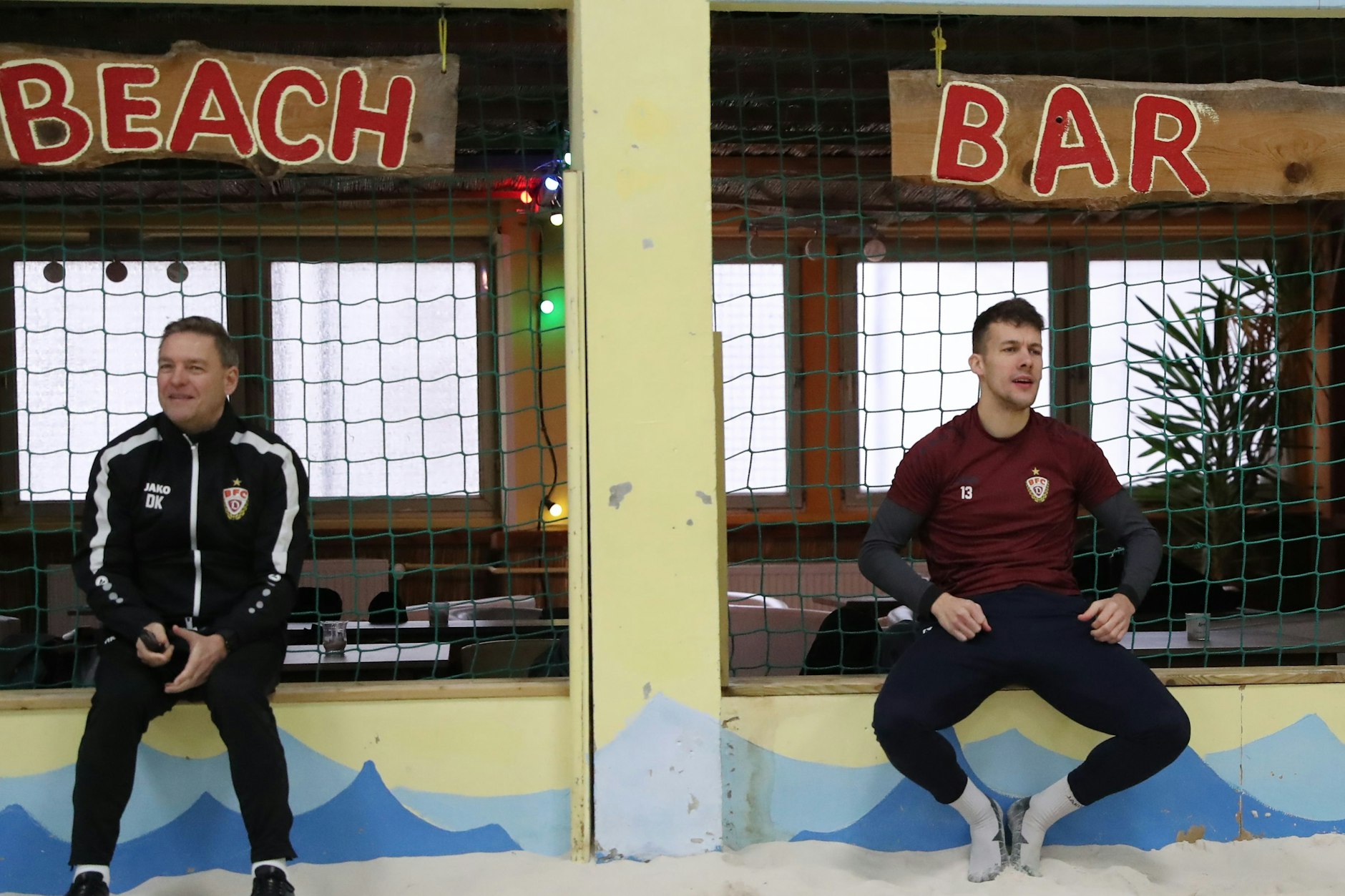 BFC-Trainer Dirk Kunert sitzt unter Beach, Chris Reher und Bar – ergibt: BFC in der Beach-Bar.