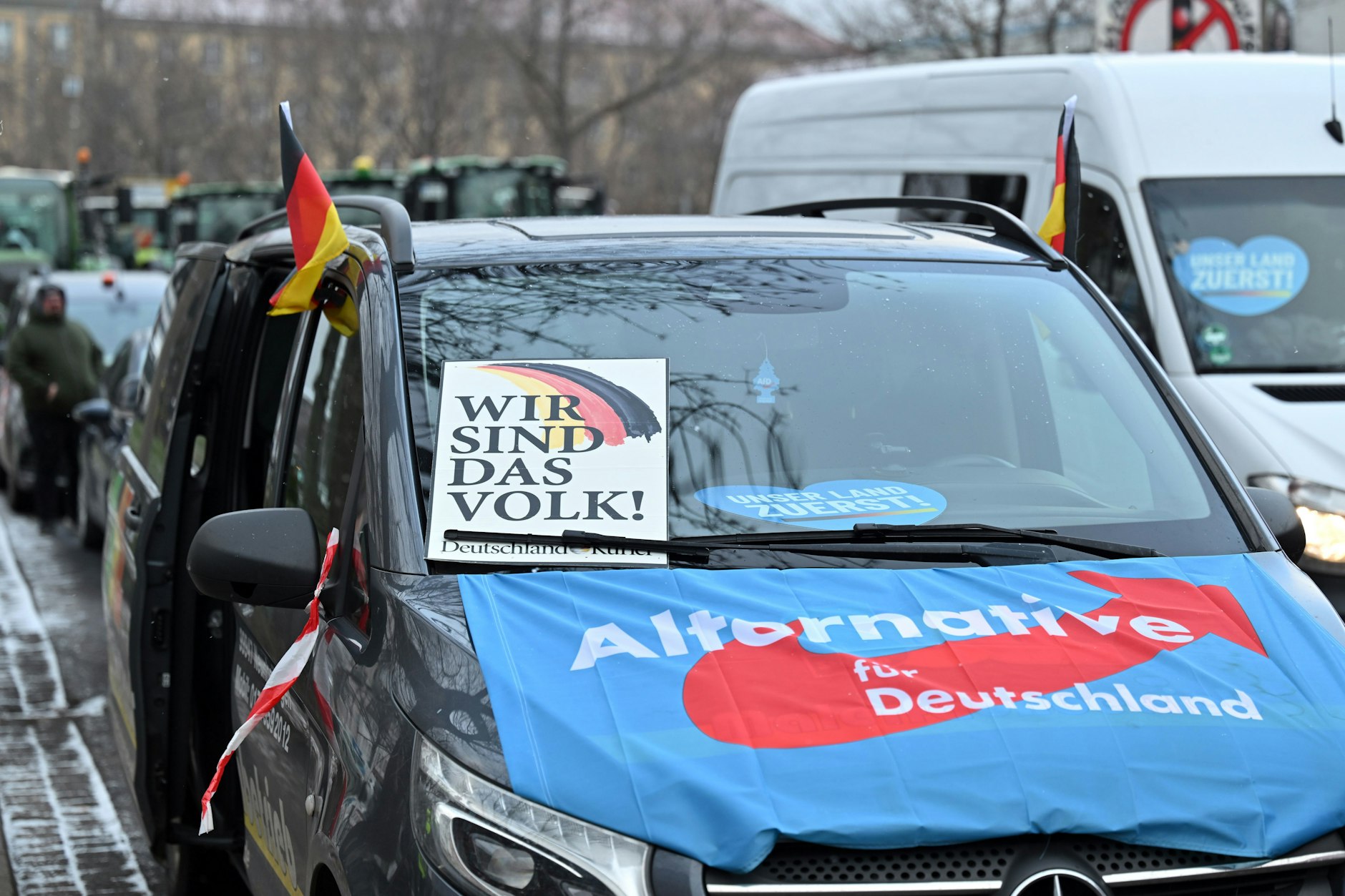 „Wir sind das Volk“ steht auf einem Plakat an einem mit einer AfD-Fahne bedeckten Fahrzeug während einer Bauernblockade in Erfurt.