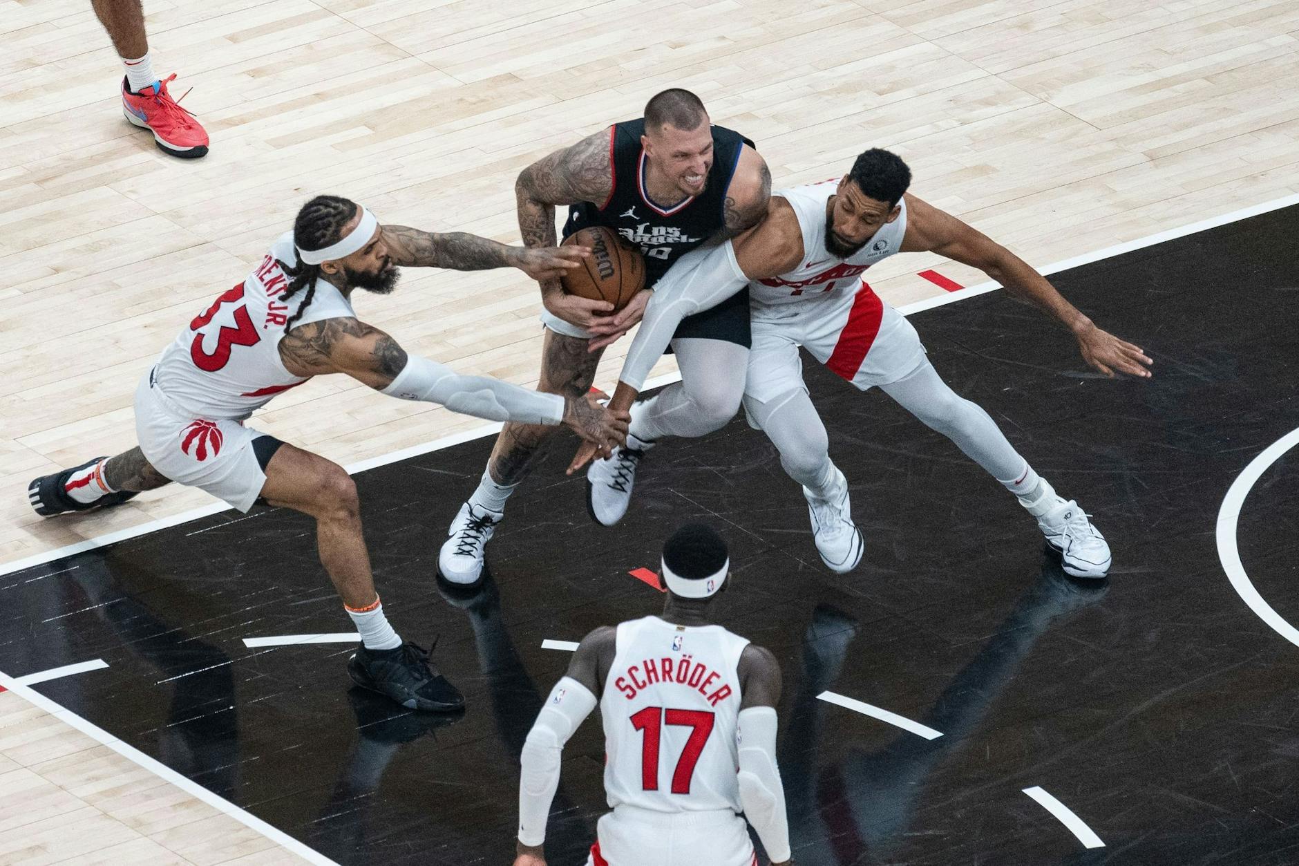 Es kommt nicht allzu oft vor, dass sich zwei Deutsche in der NBA gegenüberstehen: Hier kämpft Daniel Theis (Mitte) von den Los Angeles Clippers gegen Dennis Schröder (unten) von den Toronto Raptors um den Ball. In der Nationalmannschaft sind die beiden Teamkollegen.