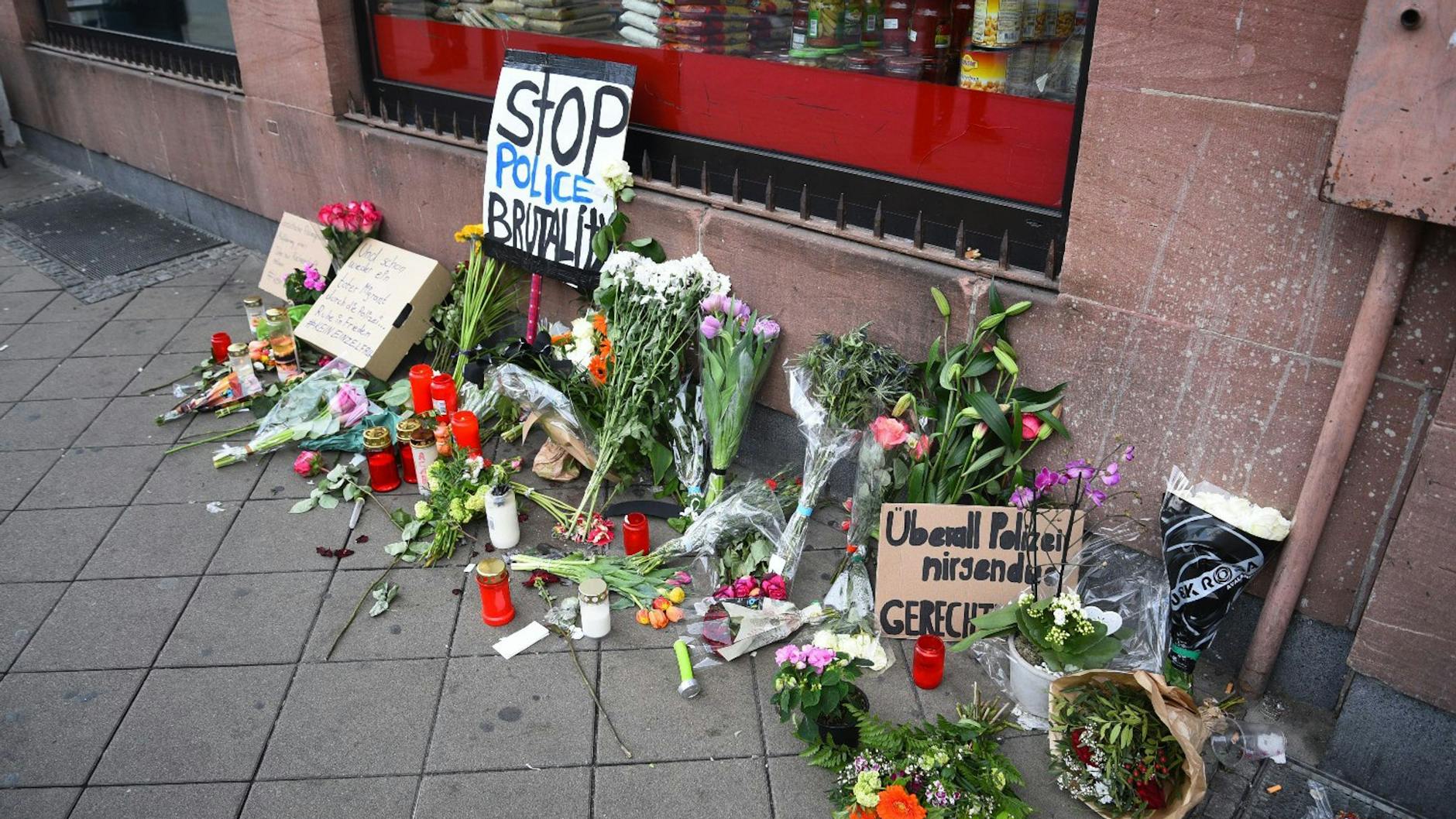 Blumen, Kerzen und Schilder liegen in Mannheim an dem Ort, an dem Ante P. Anfang Mai 2022 nach einer Polizeikontrolle starb.