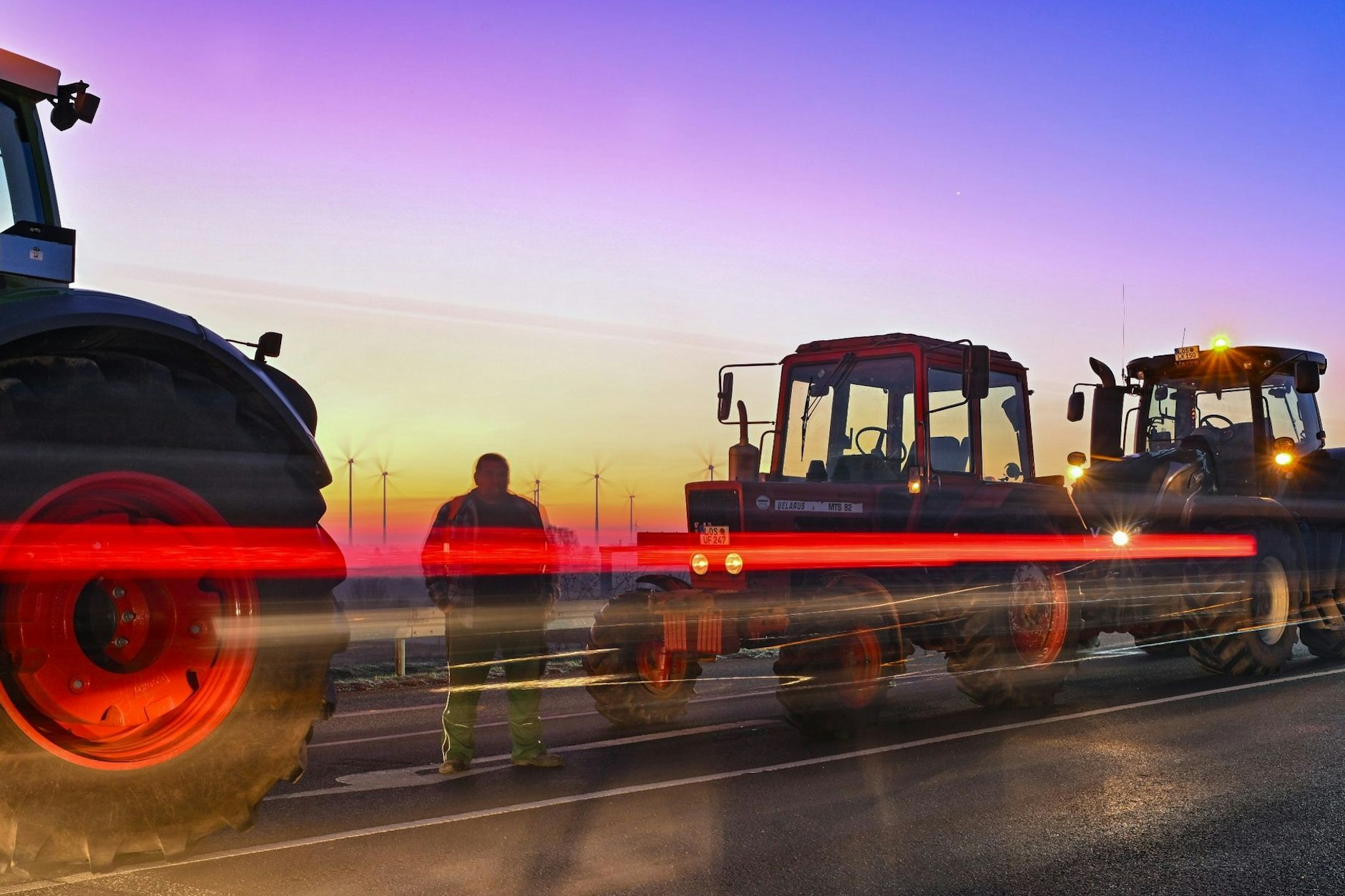Landwirte blockieren mit ihren Fahrzeugen eine Straße. 